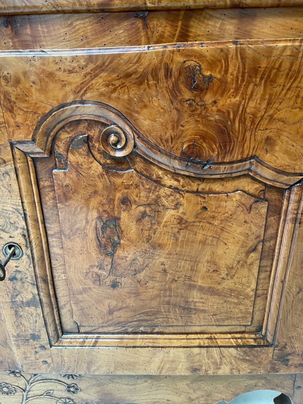 An antique two-piece French walnut cabinet featuring carved floral crests, molded panel doors, two drawers, and short cabriole feet. View VII