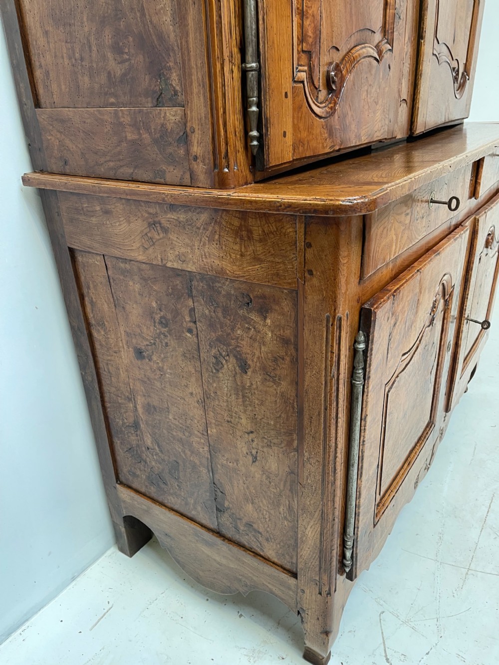 An antique two-piece French walnut cabinet featuring carved floral crests, molded panel doors, two drawers, and short cabriole feet. View X