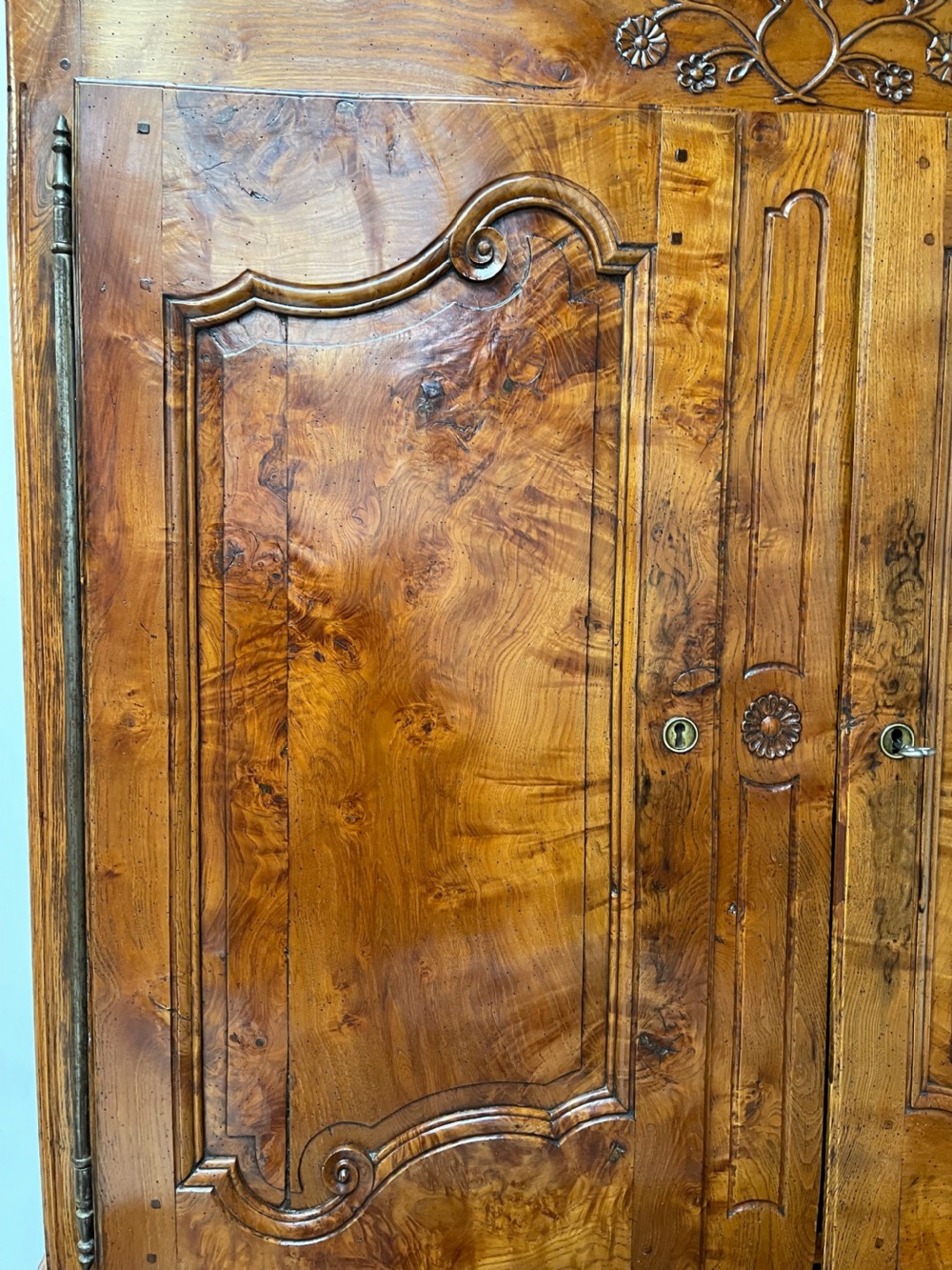 An antique two-piece French walnut cabinet featuring carved floral crests, molded panel doors, two drawers, and short cabriole feet. View XI