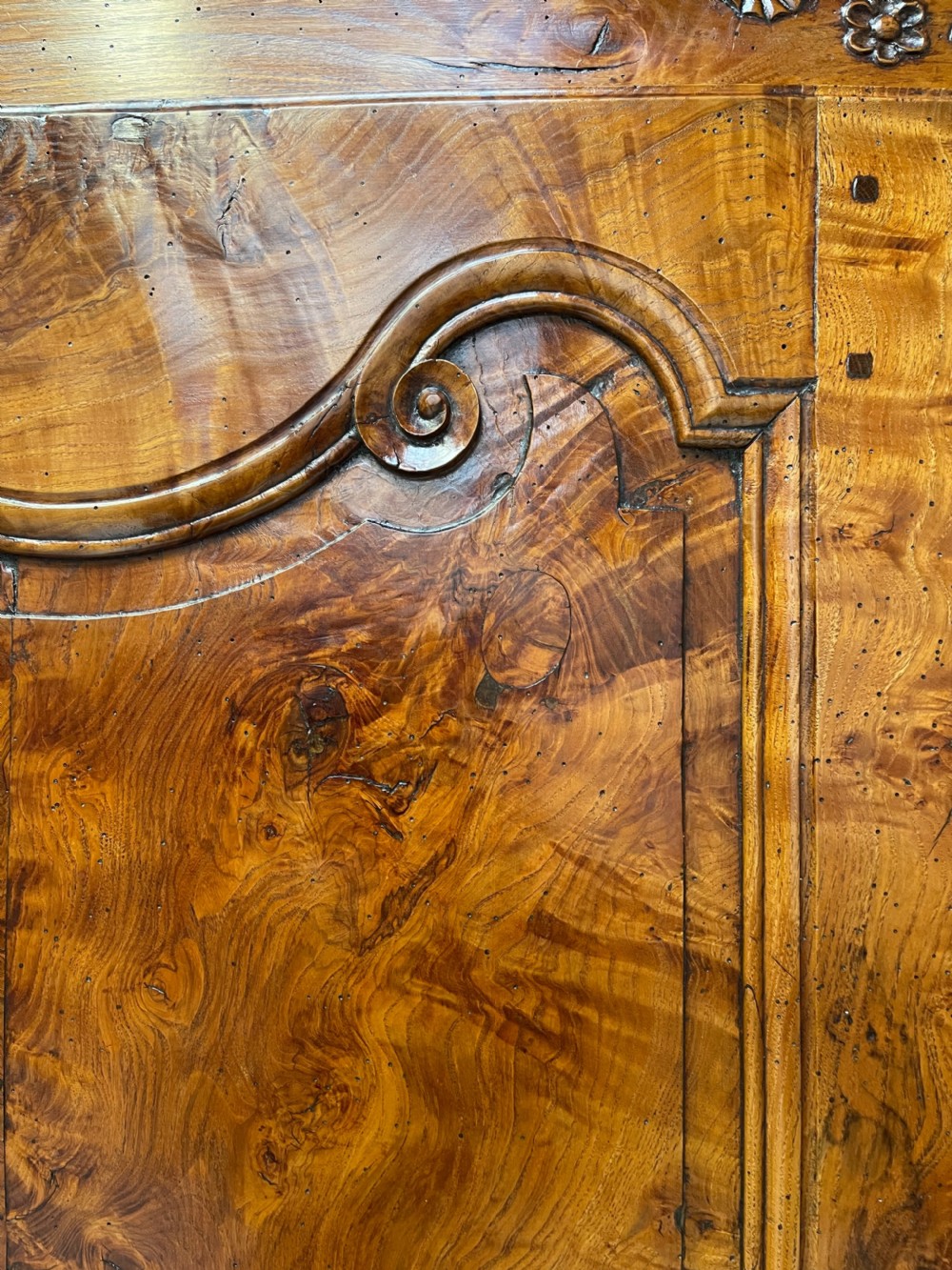 An antique two-piece French walnut cabinet featuring carved floral crests, molded panel doors, two drawers, and short cabriole feet. View XII