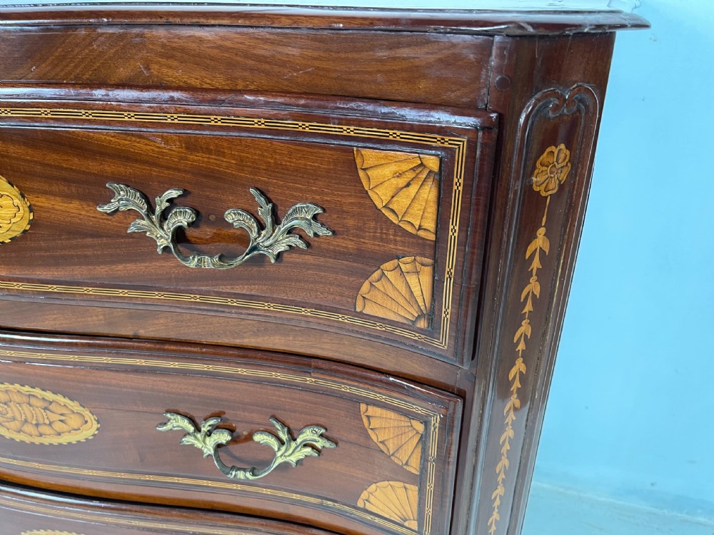 An 18th-century French walnut commode featuring three drawers with elaborate fruitwood marquetry inlays, cast brass escutcheons, and curved cabriole legs. View II