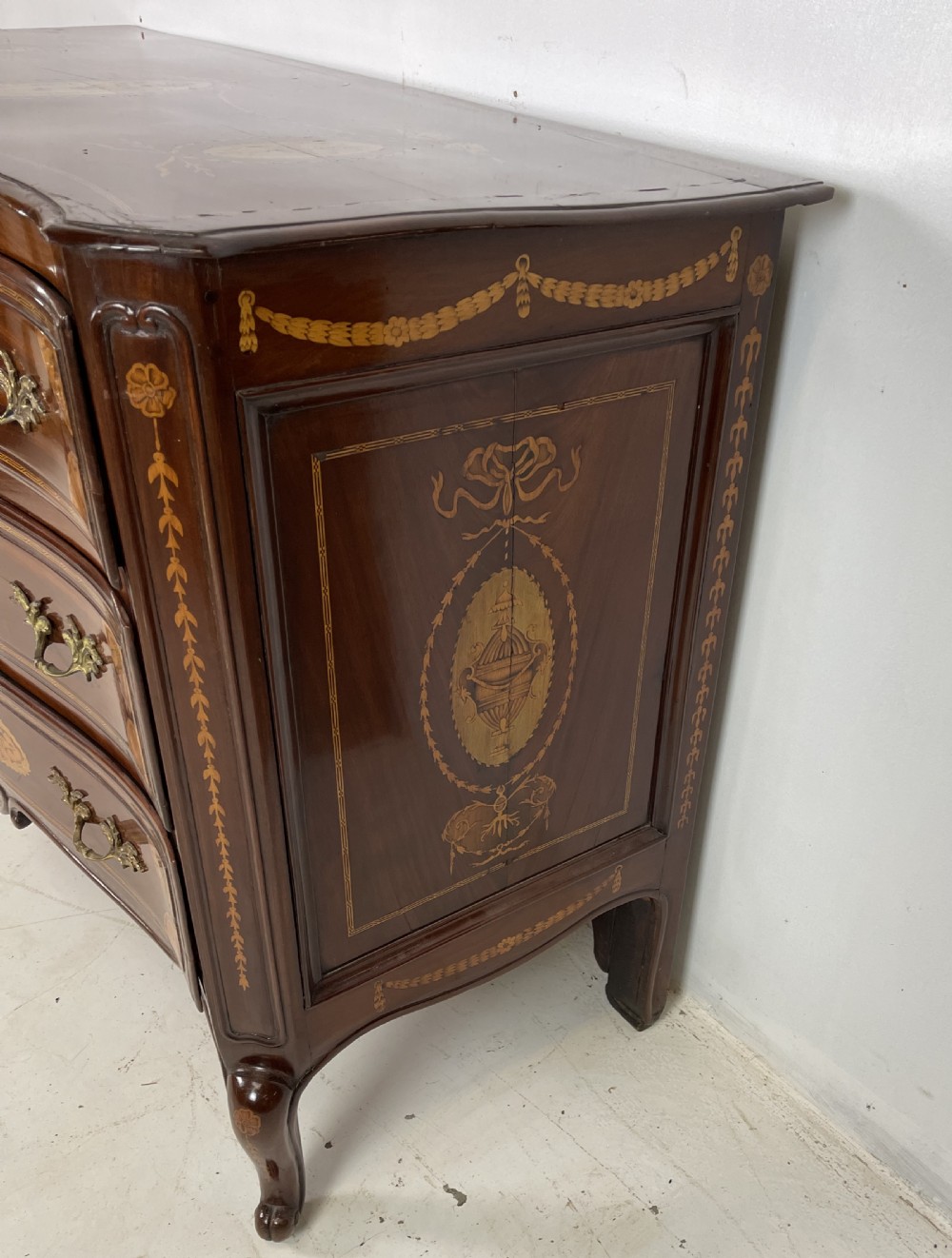 An 18th-century French walnut commode featuring three drawers with elaborate fruitwood marquetry inlays, cast brass escutcheons, and curved cabriole legs. View III