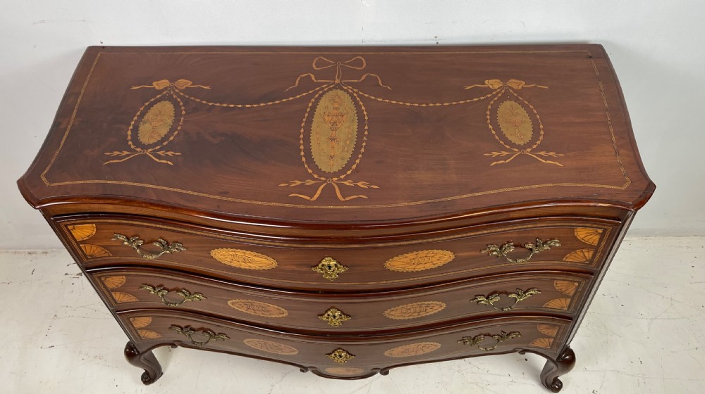 An 18th-century French walnut commode featuring three drawers with elaborate fruitwood marquetry inlays, cast brass escutcheons, and curved cabriole legs. View VI