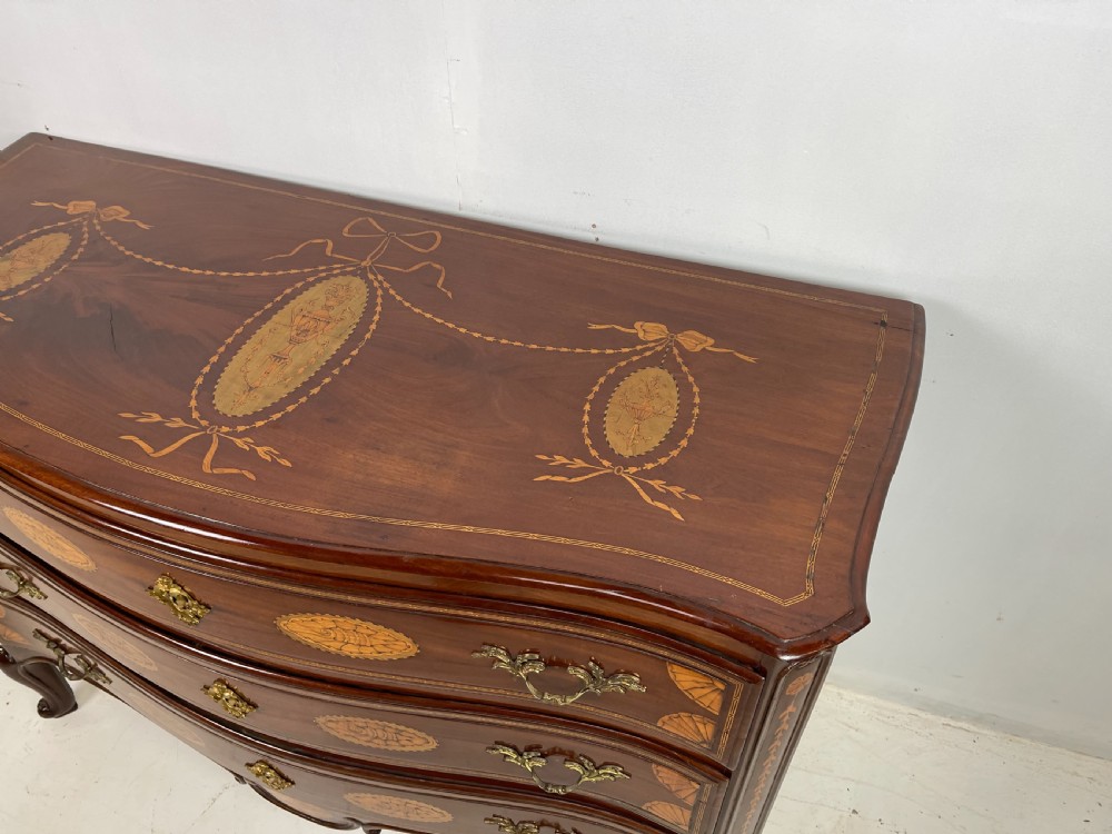 An 18th-century French walnut commode featuring three drawers with elaborate fruitwood marquetry inlays, cast brass escutcheons, and curved cabriole legs. View VIII