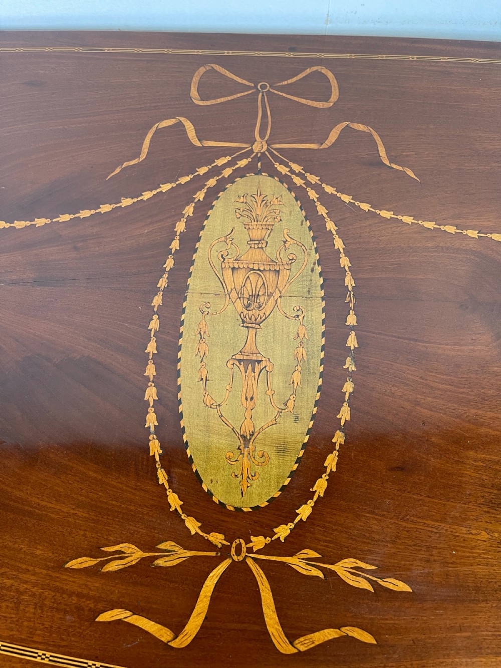 An 18th-century French walnut commode featuring three drawers with elaborate fruitwood marquetry inlays, cast brass escutcheons, and curved cabriole legs. View XI