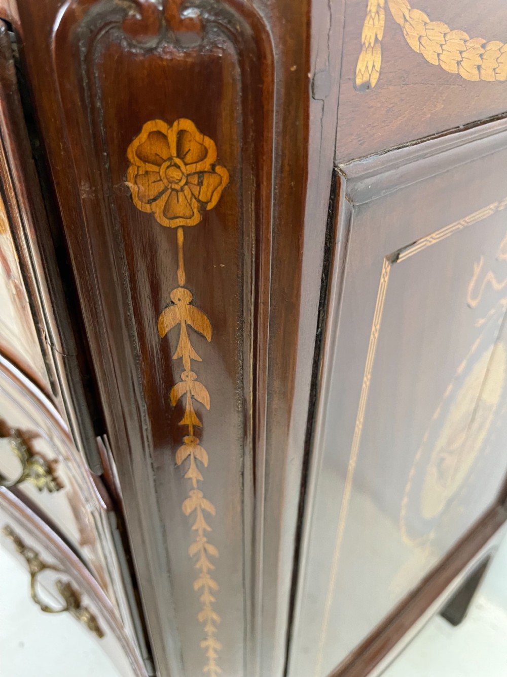 An 18th-century French walnut commode featuring three drawers with elaborate fruitwood marquetry inlays, cast brass escutcheons, and curved cabriole legs. View XIII