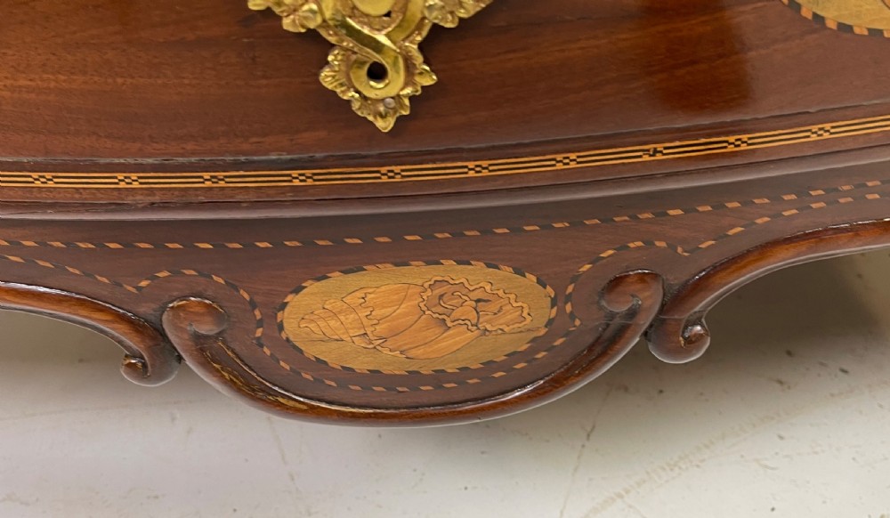 An 18th-century French walnut commode featuring three drawers with elaborate fruitwood marquetry inlays, cast brass escutcheons, and curved cabriole legs. View XIV