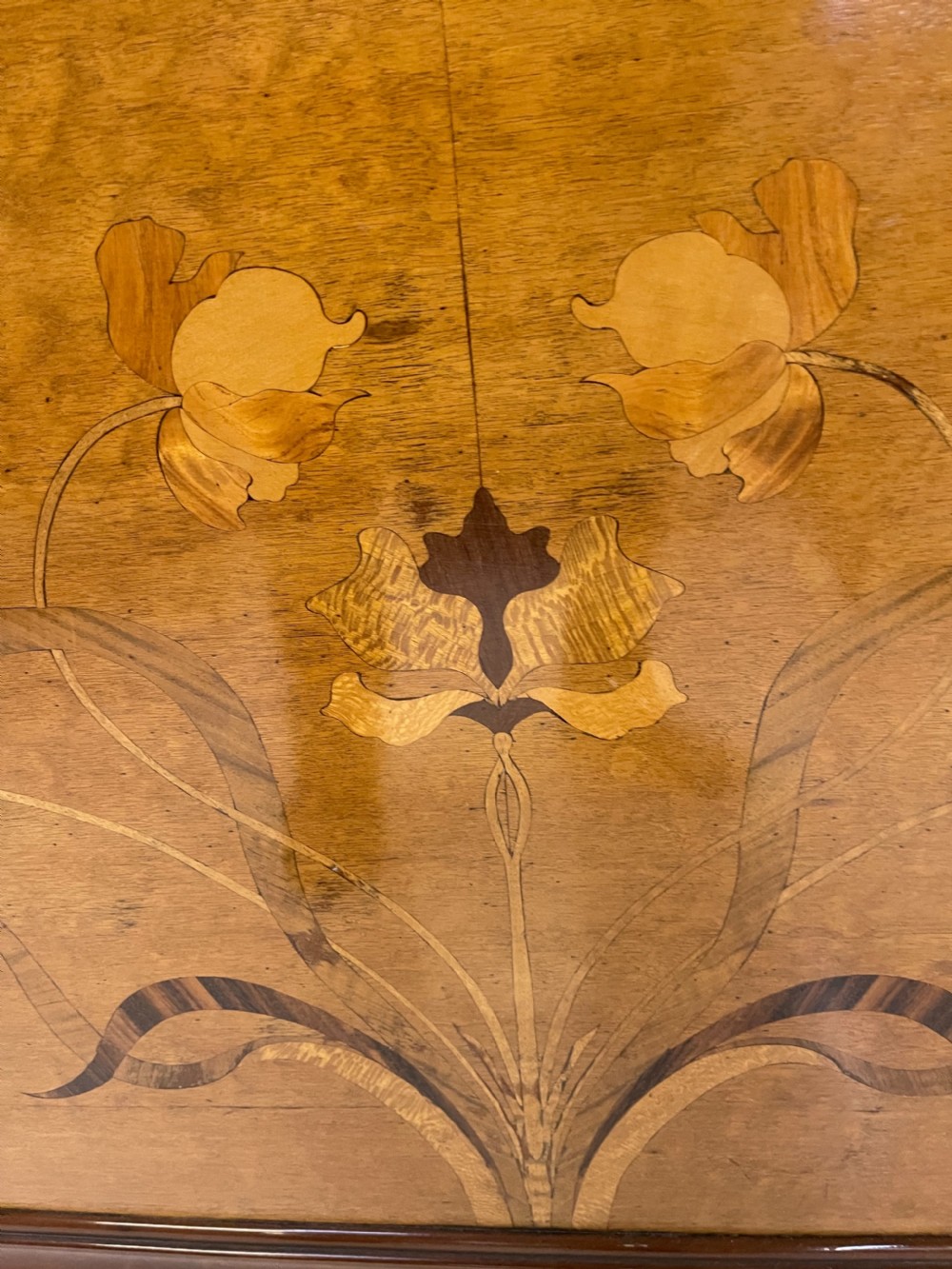 An Art Nouveau wooden bed frame featuring floral marquetry inlay on the headboard and footboard with carved organic scrollwork. View III