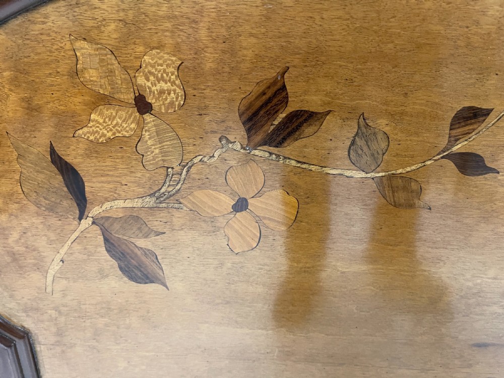 An Art Nouveau wooden bed frame featuring floral marquetry inlay on the headboard and footboard with carved organic scrollwork. View IV