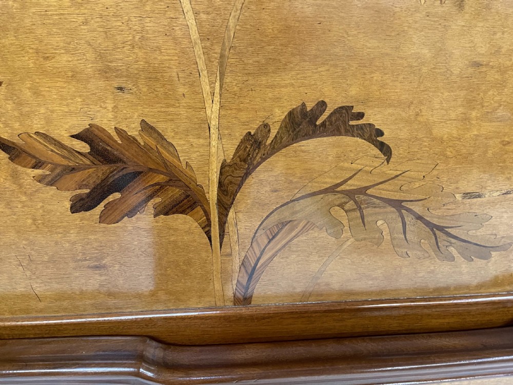 An Art Nouveau wooden bed frame featuring floral marquetry inlay on the headboard and footboard with carved organic scrollwork. View IX