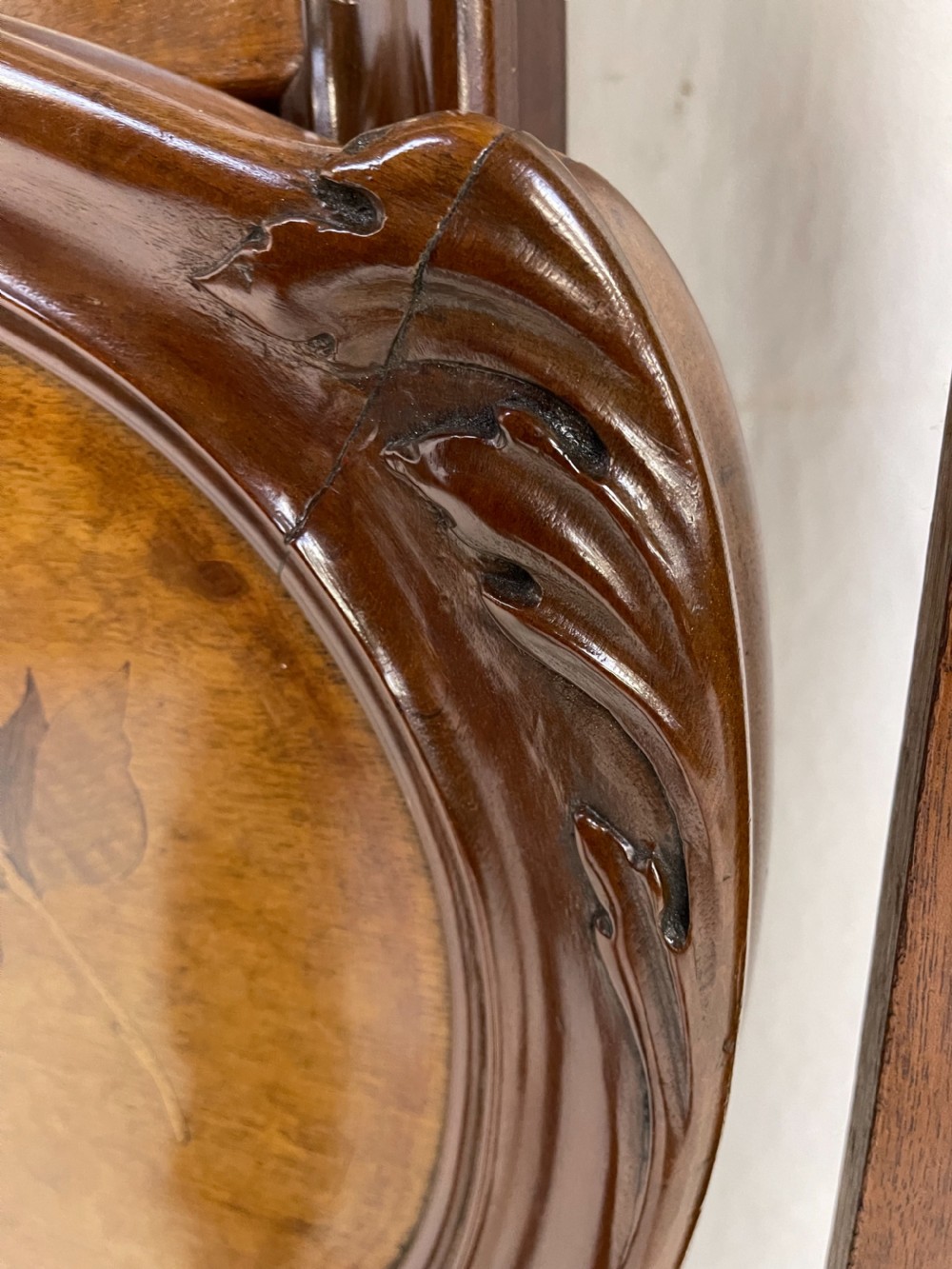 An Art Nouveau wooden bed frame featuring floral marquetry inlay on the headboard and footboard with carved organic scrollwork. View XIII