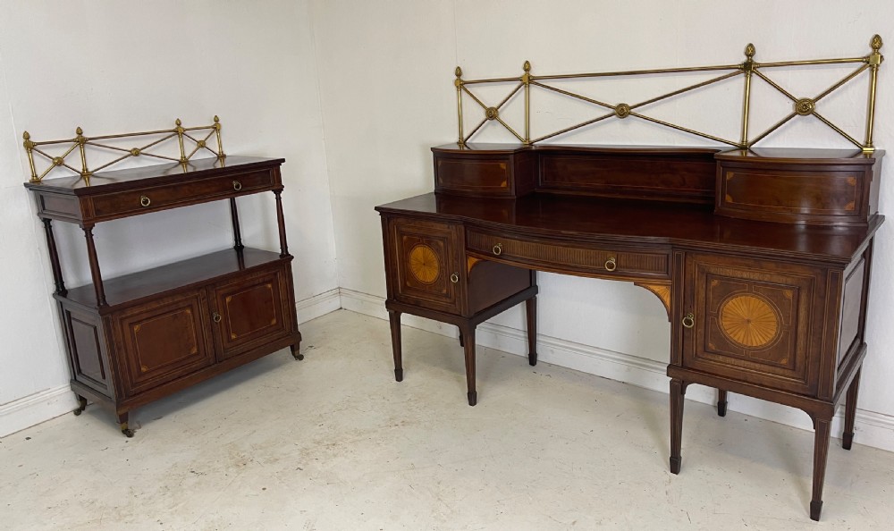 An inlaid mahogany sideboard and matching serving table featuring brass gallery rails and satinwood fan marquetry.