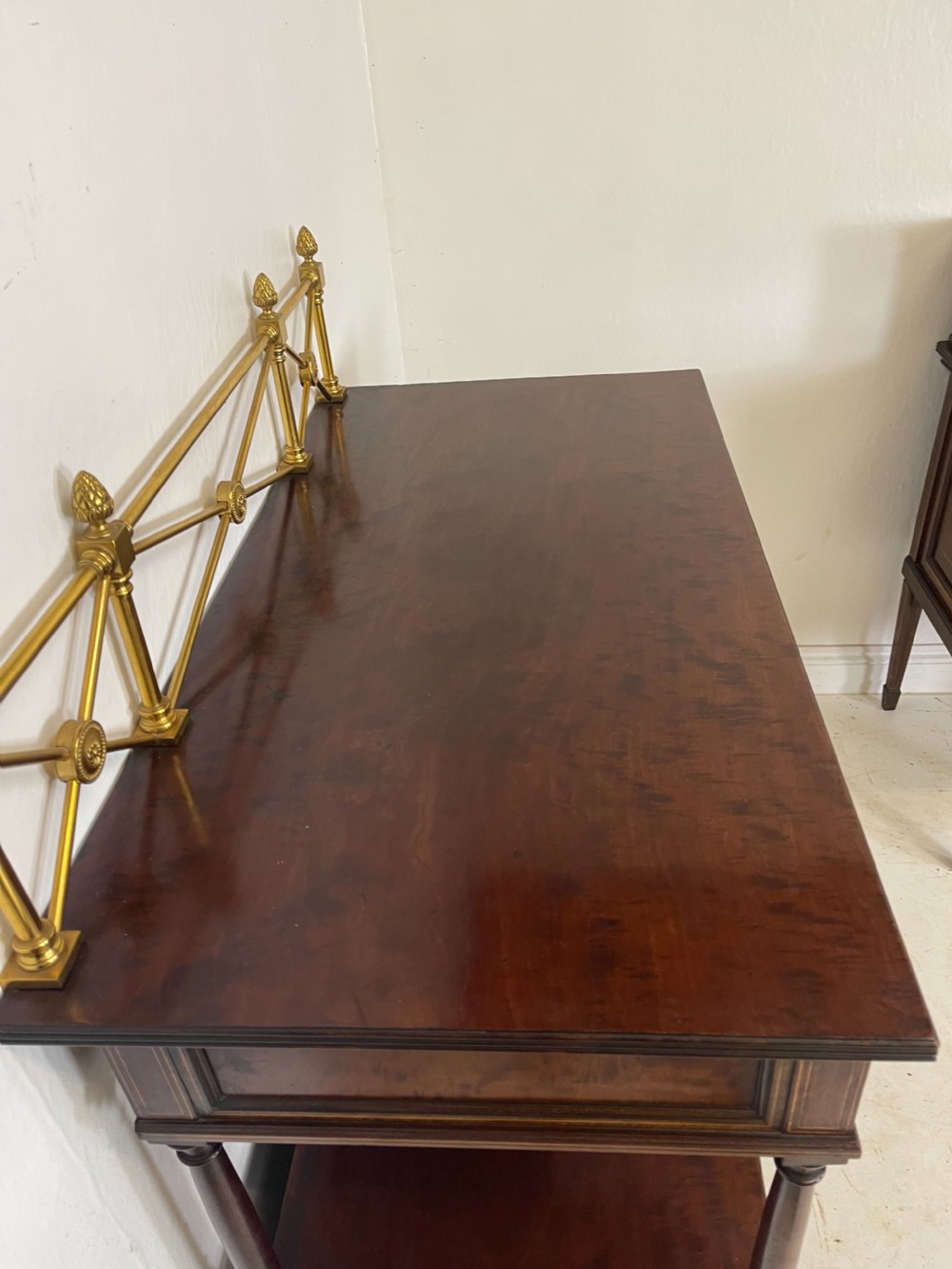 An inlaid mahogany sideboard and matching serving table featuring brass gallery rails and satinwood fan marquetry. View X