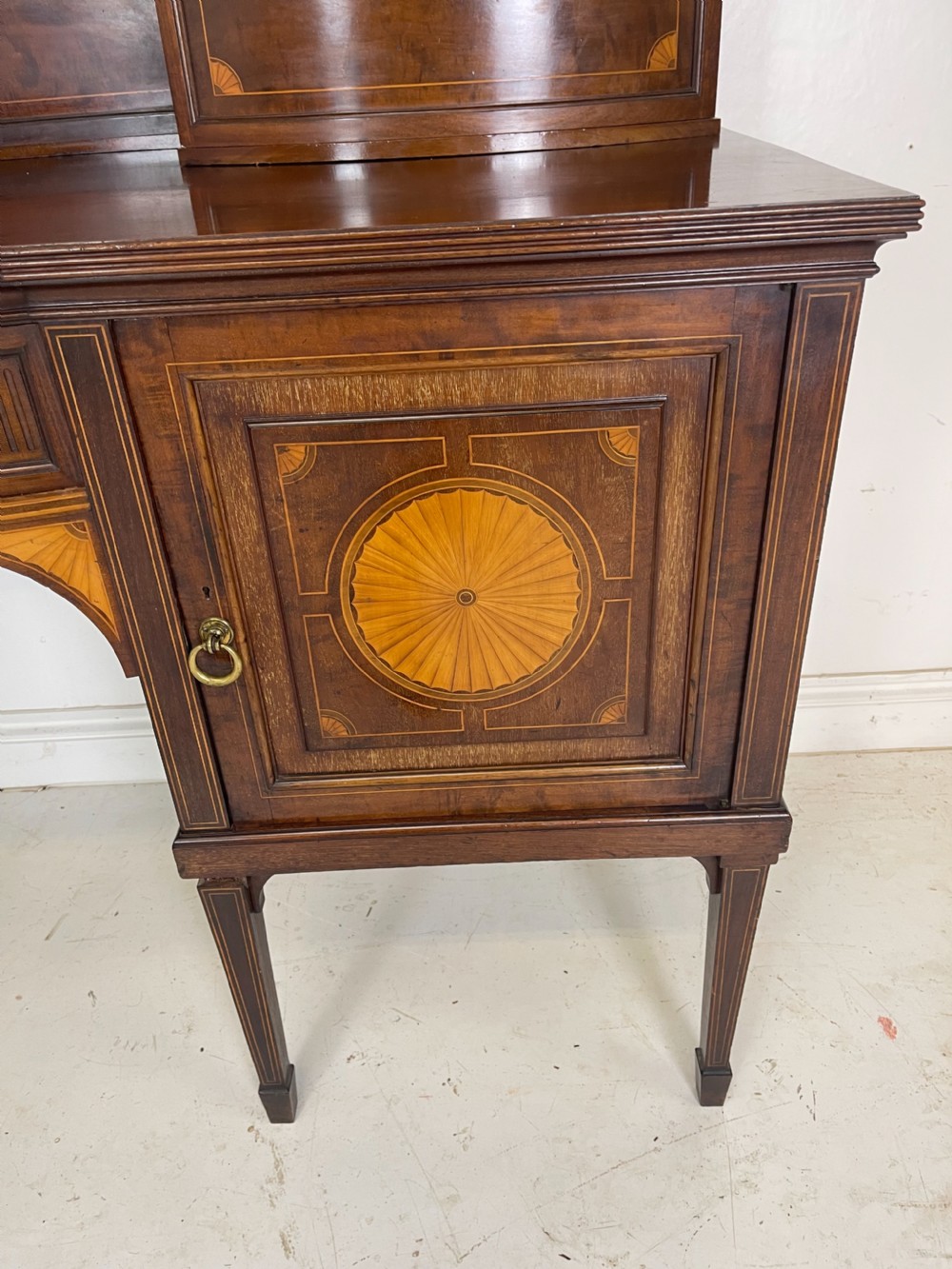 An inlaid mahogany sideboard and matching serving table featuring brass gallery rails and satinwood fan marquetry. View XII