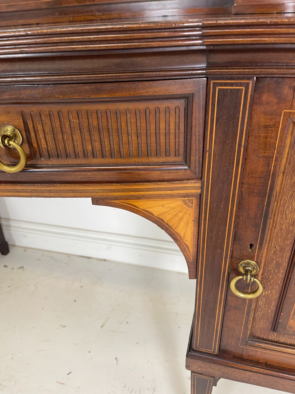 An inlaid mahogany sideboard and matching serving table featuring brass gallery rails and satinwood fan marquetry. View XIII