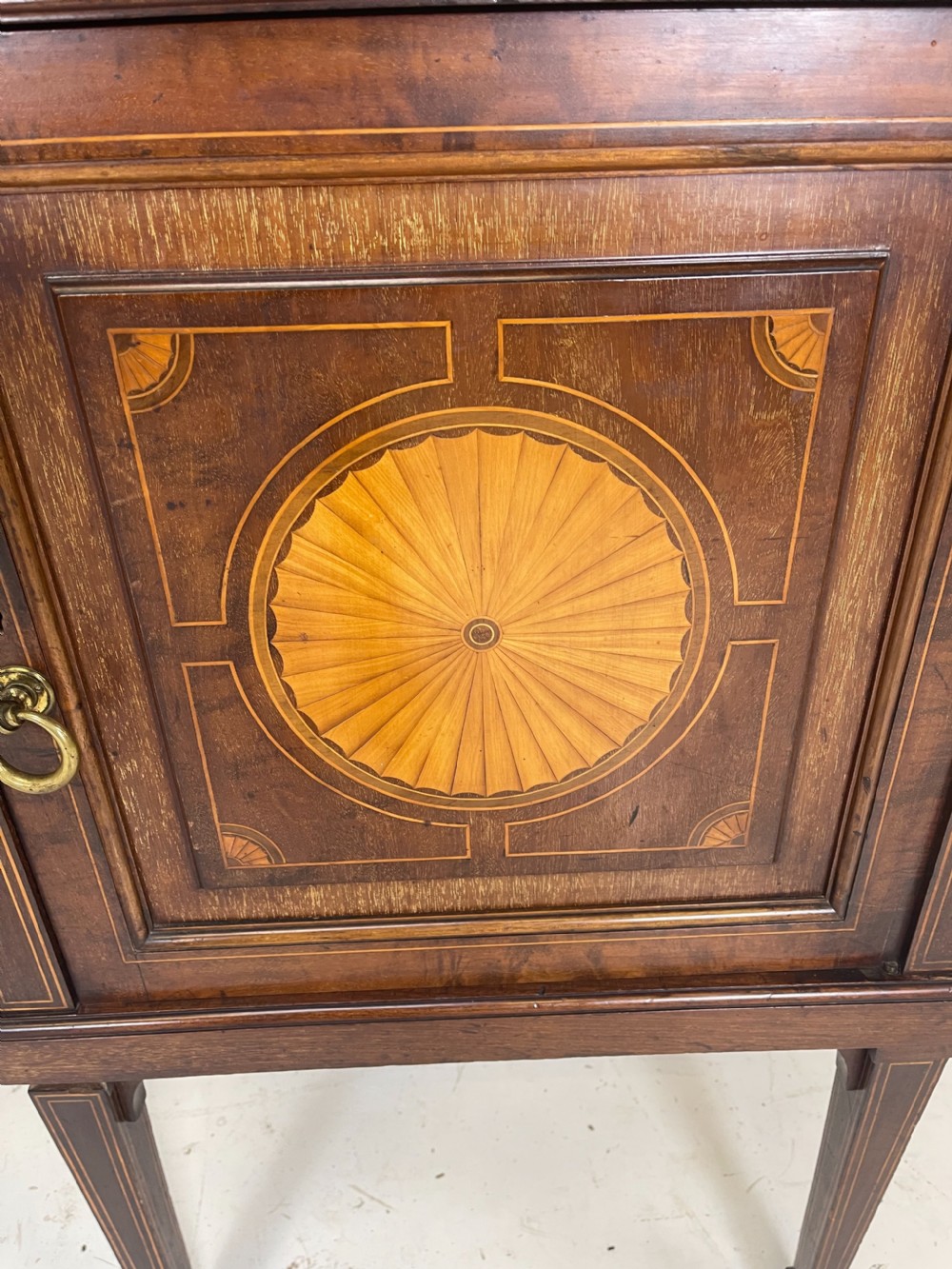 An inlaid mahogany sideboard and matching serving table featuring brass gallery rails and satinwood fan marquetry. View XIX