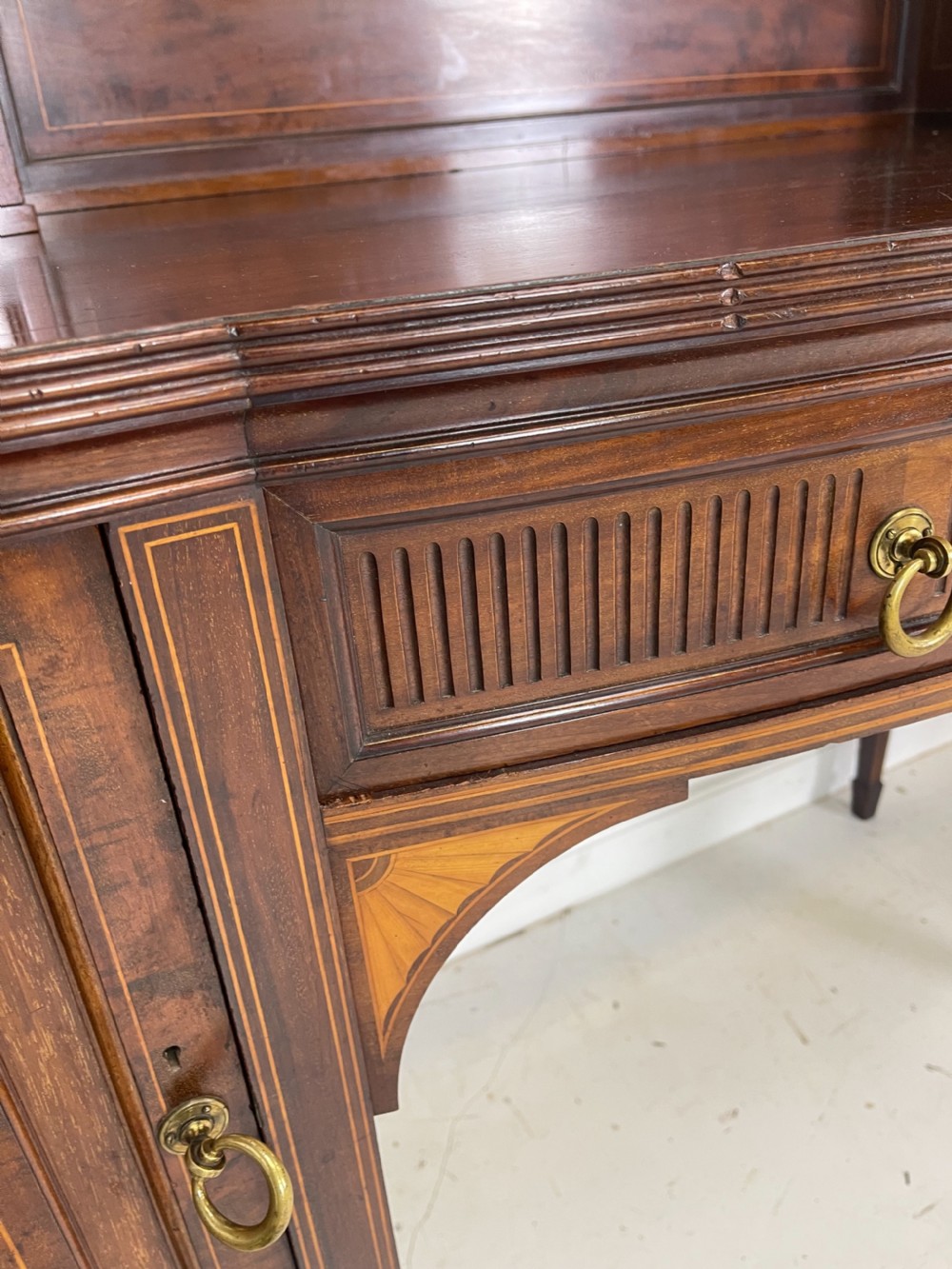 An inlaid mahogany sideboard and matching serving table featuring brass gallery rails and satinwood fan marquetry. View XXII