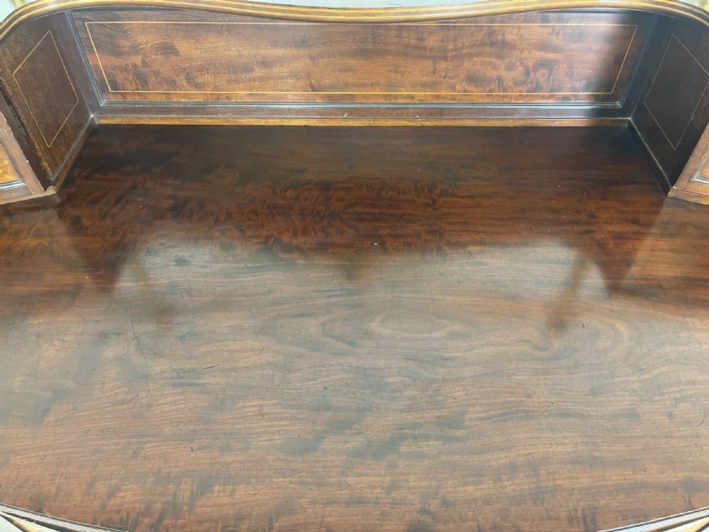 An inlaid mahogany sideboard and matching serving table featuring brass gallery rails and satinwood fan marquetry. View XXIX