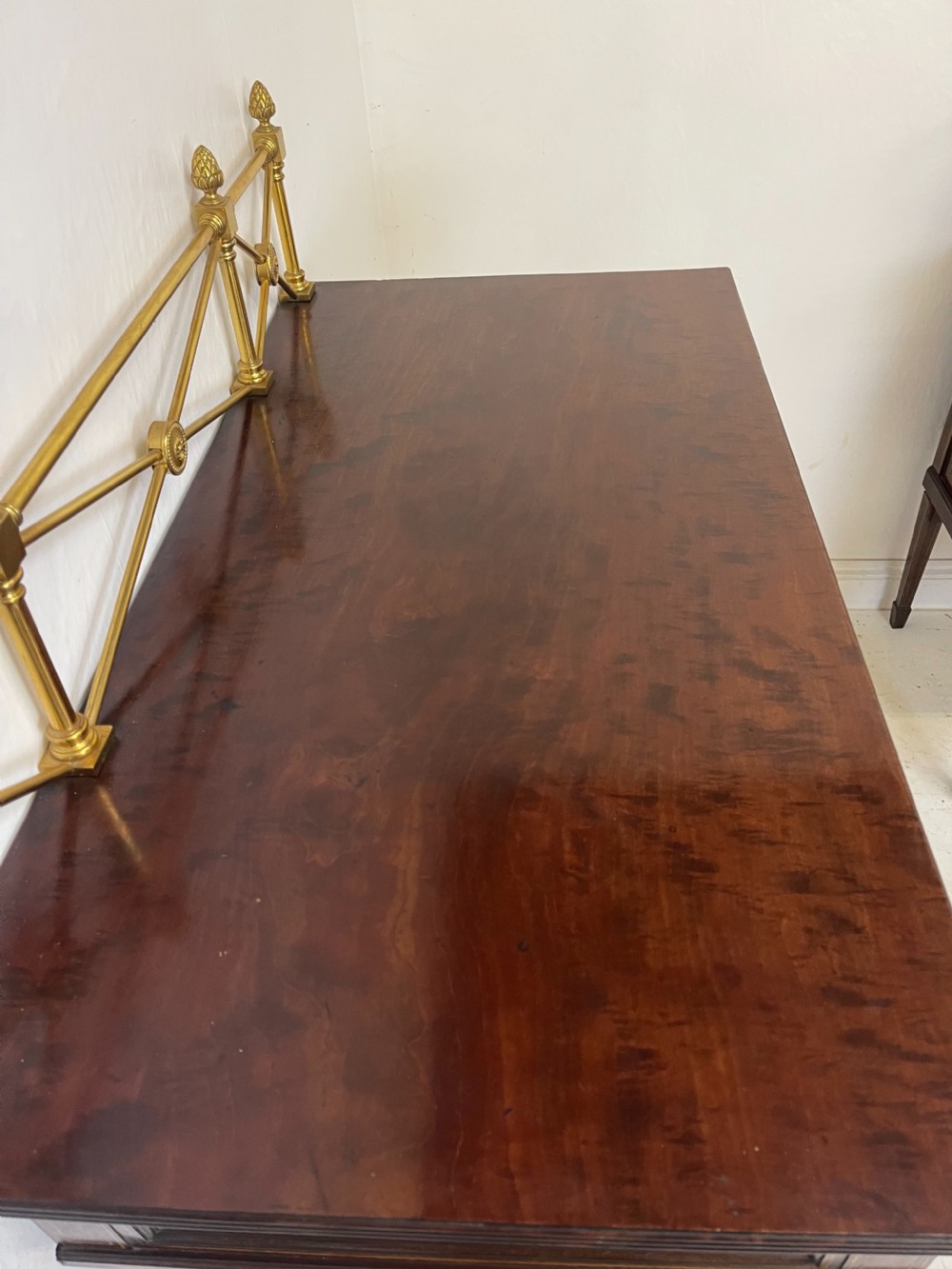 An inlaid mahogany sideboard and matching serving table featuring brass gallery rails and satinwood fan marquetry. View XXX