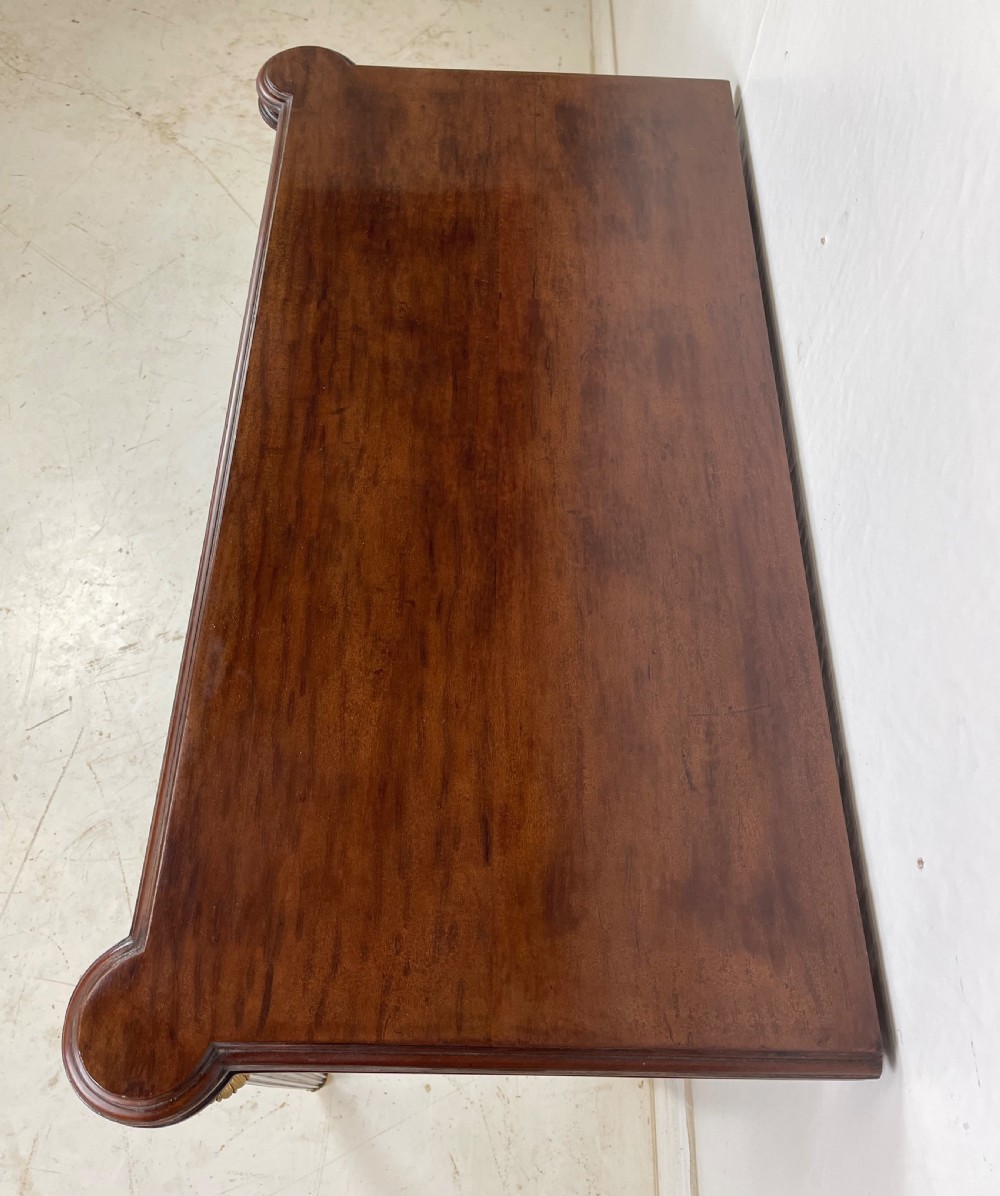 A polished dark mahogany fold-over card table featuring tapered fluted legs topped with gilt bronze acanthus collars. View III