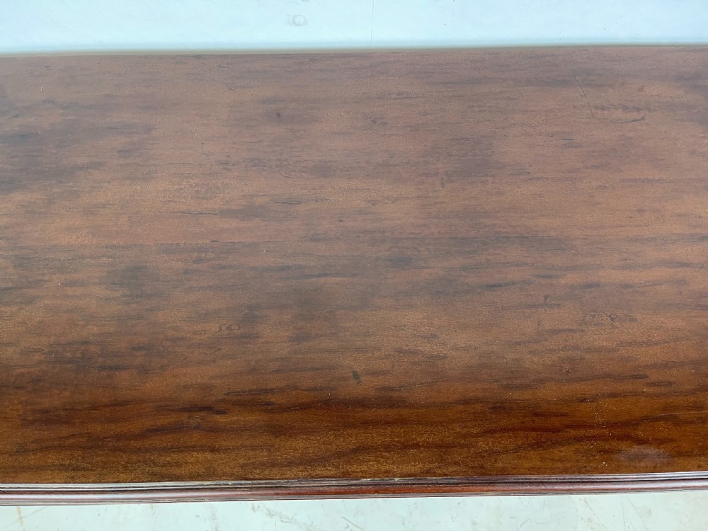 A polished dark mahogany fold-over card table featuring tapered fluted legs topped with gilt bronze acanthus collars. View V