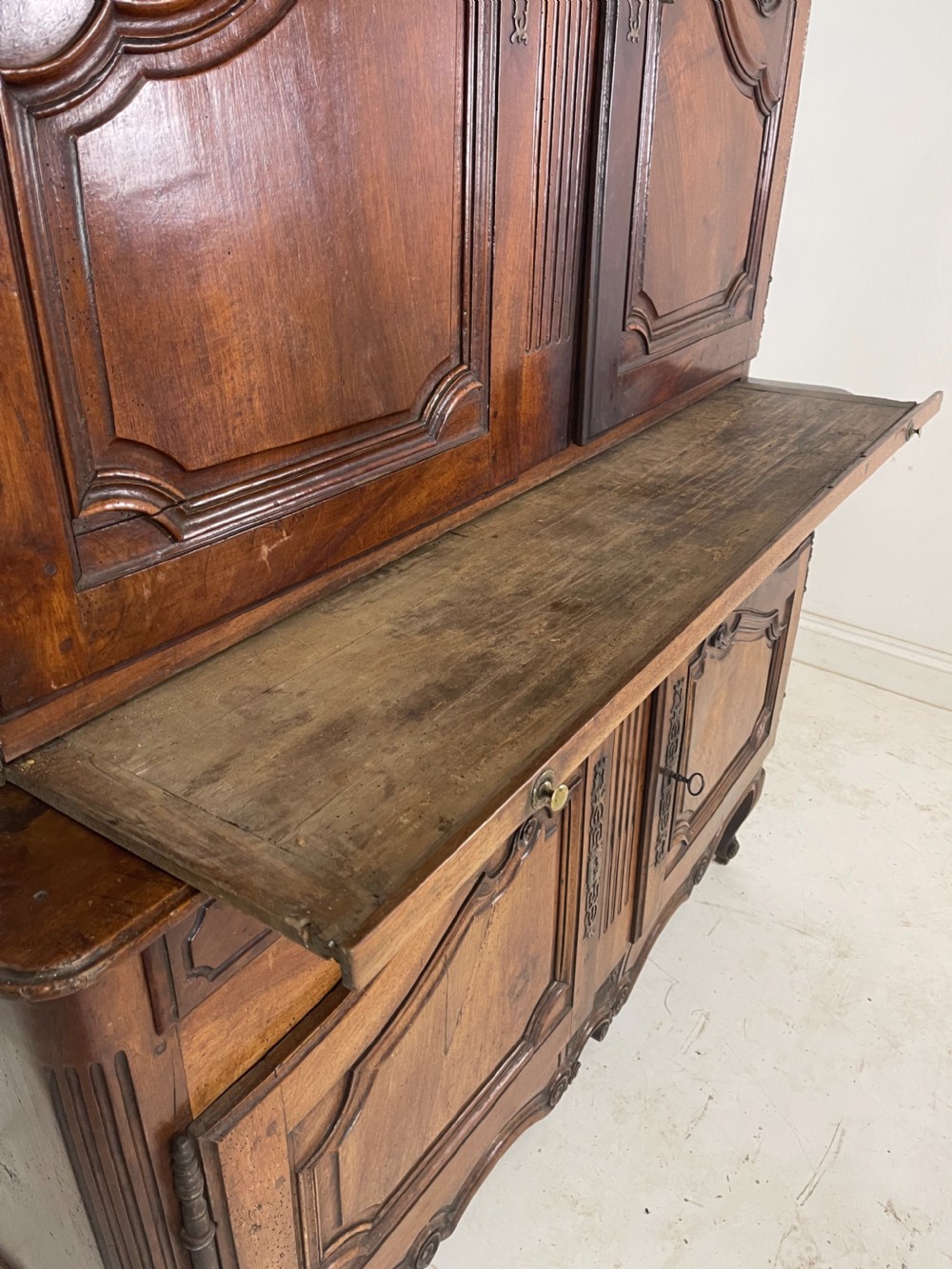 An antique French provincial walnut buffet deux corps featuring two upper panelled doors under a shaped cornice, two lower drawers, and carved cupboard doors resting on short cabriole feet. View III