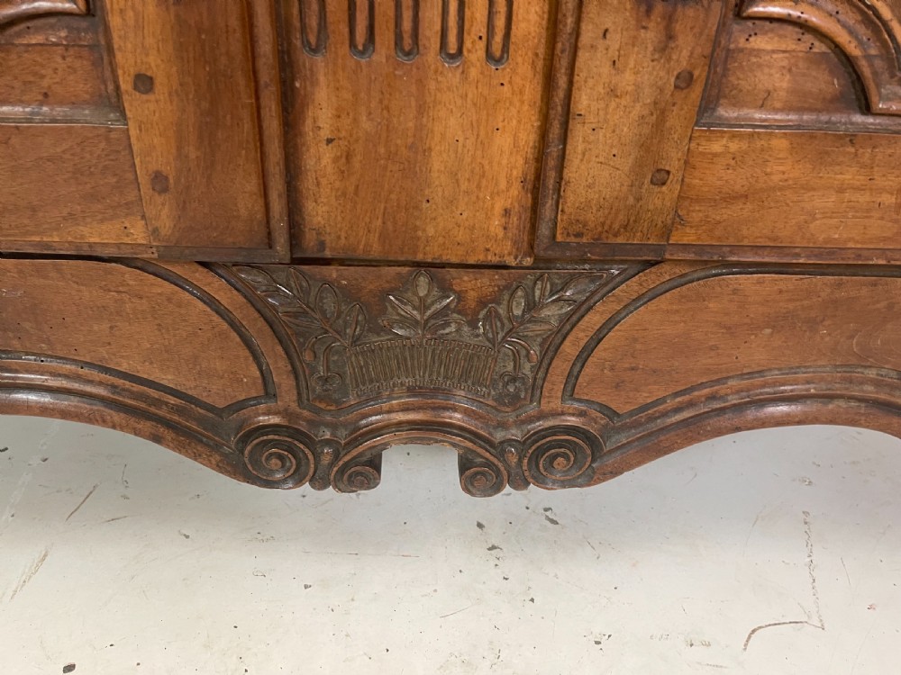An antique French provincial walnut buffet deux corps featuring two upper panelled doors under a shaped cornice, two lower drawers, and carved cupboard doors resting on short cabriole feet. View IV