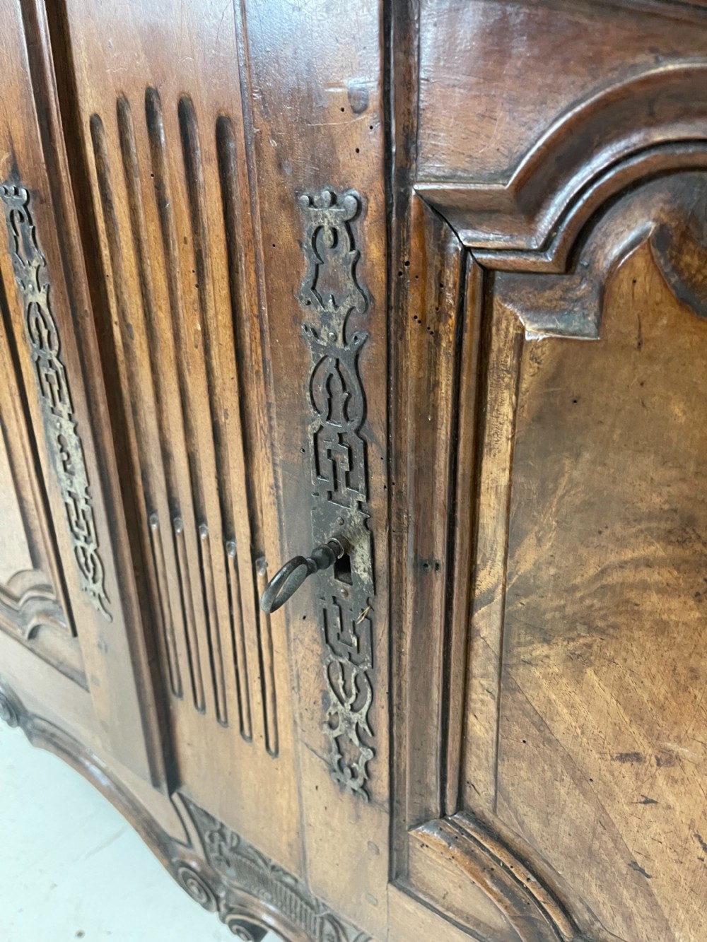 An antique French provincial walnut buffet deux corps featuring two upper panelled doors under a shaped cornice, two lower drawers, and carved cupboard doors resting on short cabriole feet. View V