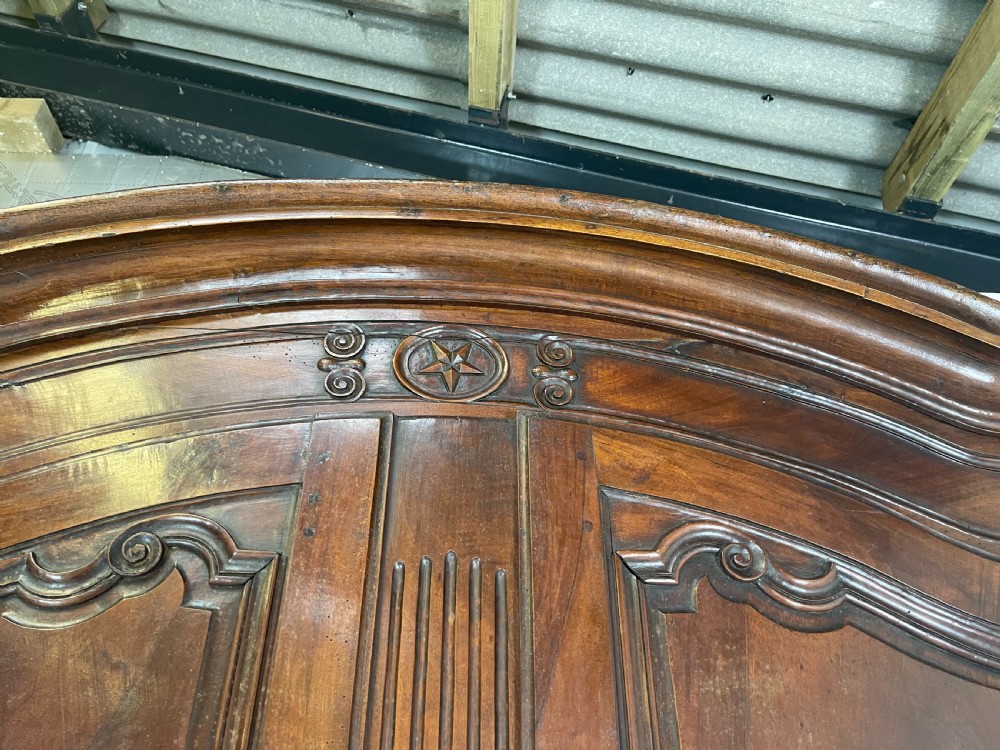 An antique French provincial walnut buffet deux corps featuring two upper panelled doors under a shaped cornice, two lower drawers, and carved cupboard doors resting on short cabriole feet. View X
