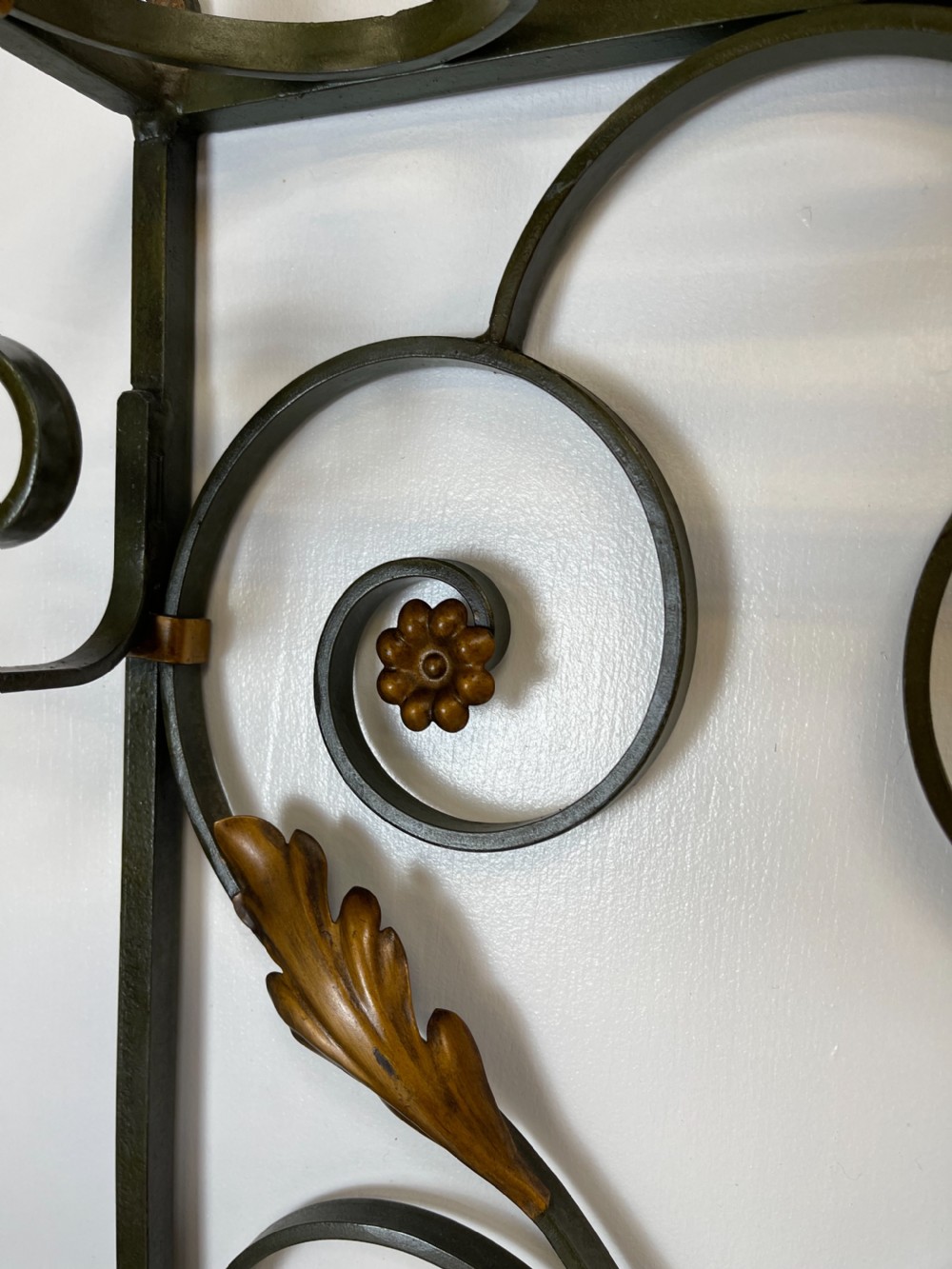 A tall French Art Deco wrought iron hall stand featuring symmetrical scrollwork with gold leaf accents, a central full-length mirror, multiple hooks, and umbrella drip trays. View III
