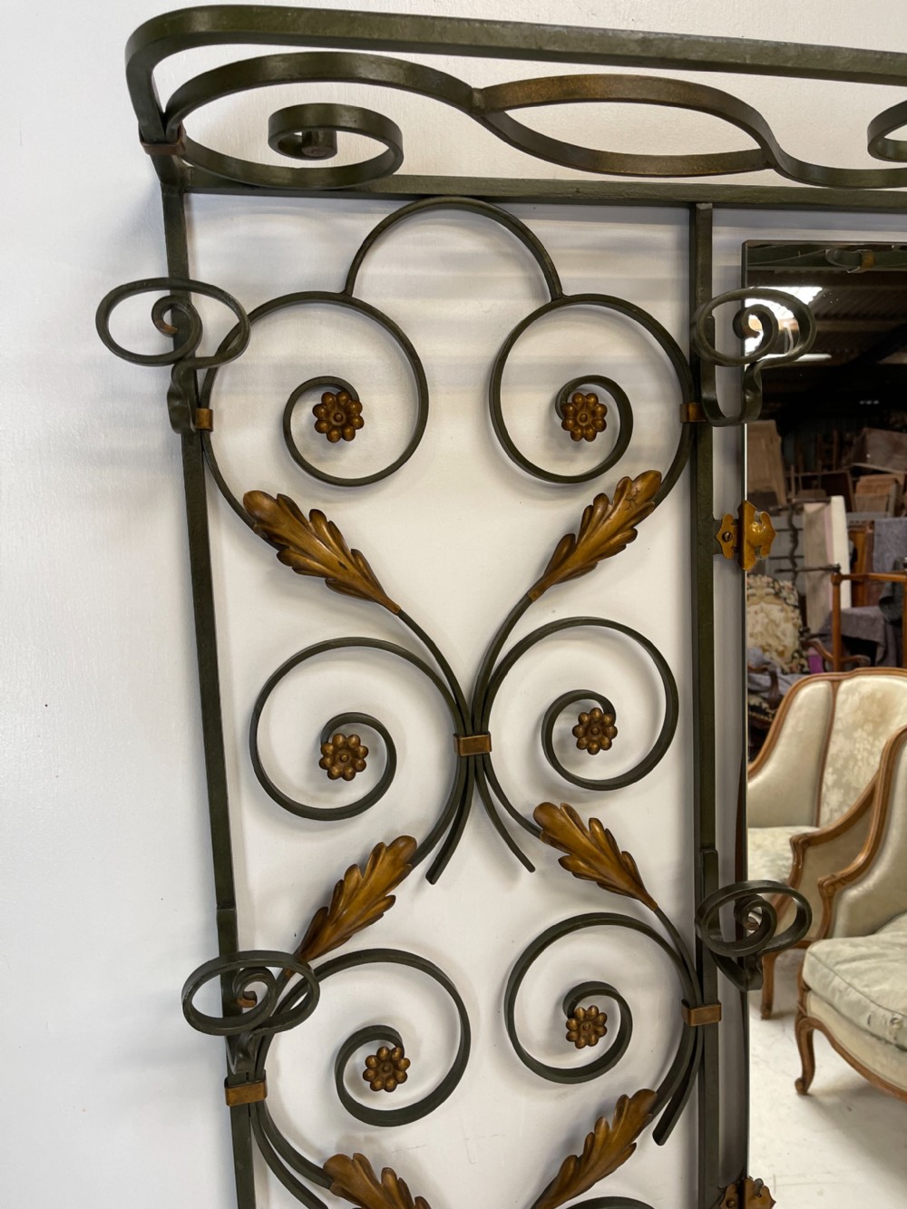 A tall French Art Deco wrought iron hall stand featuring symmetrical scrollwork with gold leaf accents, a central full-length mirror, multiple hooks, and umbrella drip trays. View VIII