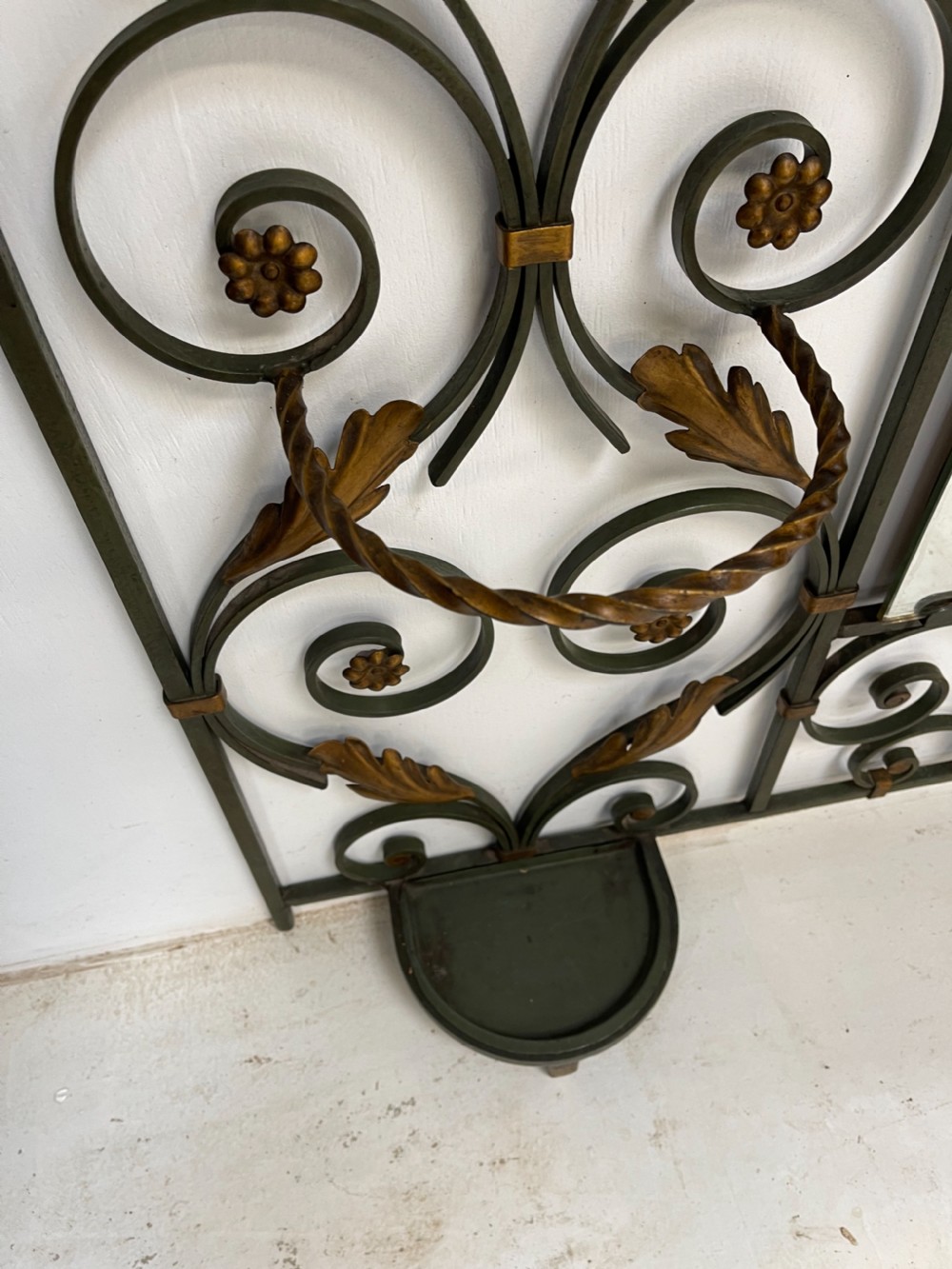 A tall French Art Deco wrought iron hall stand featuring symmetrical scrollwork with gold leaf accents, a central full-length mirror, multiple hooks, and umbrella drip trays. View XII