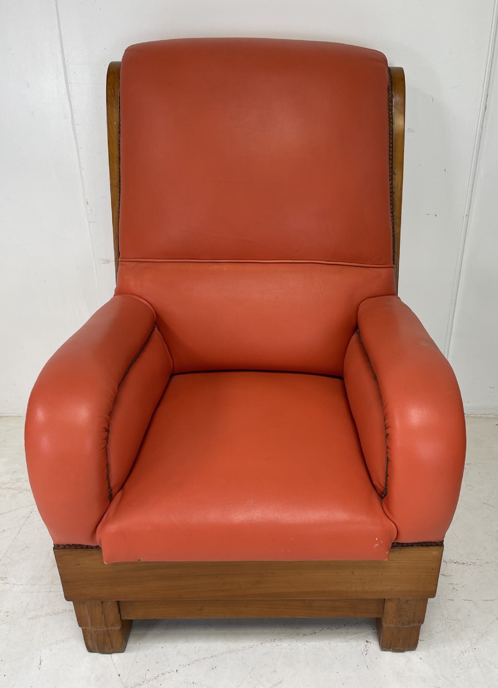 A pair of Art Deco high-backed armchairs upholstered in terracotta orange leather with dark wooden frames and bases. View III