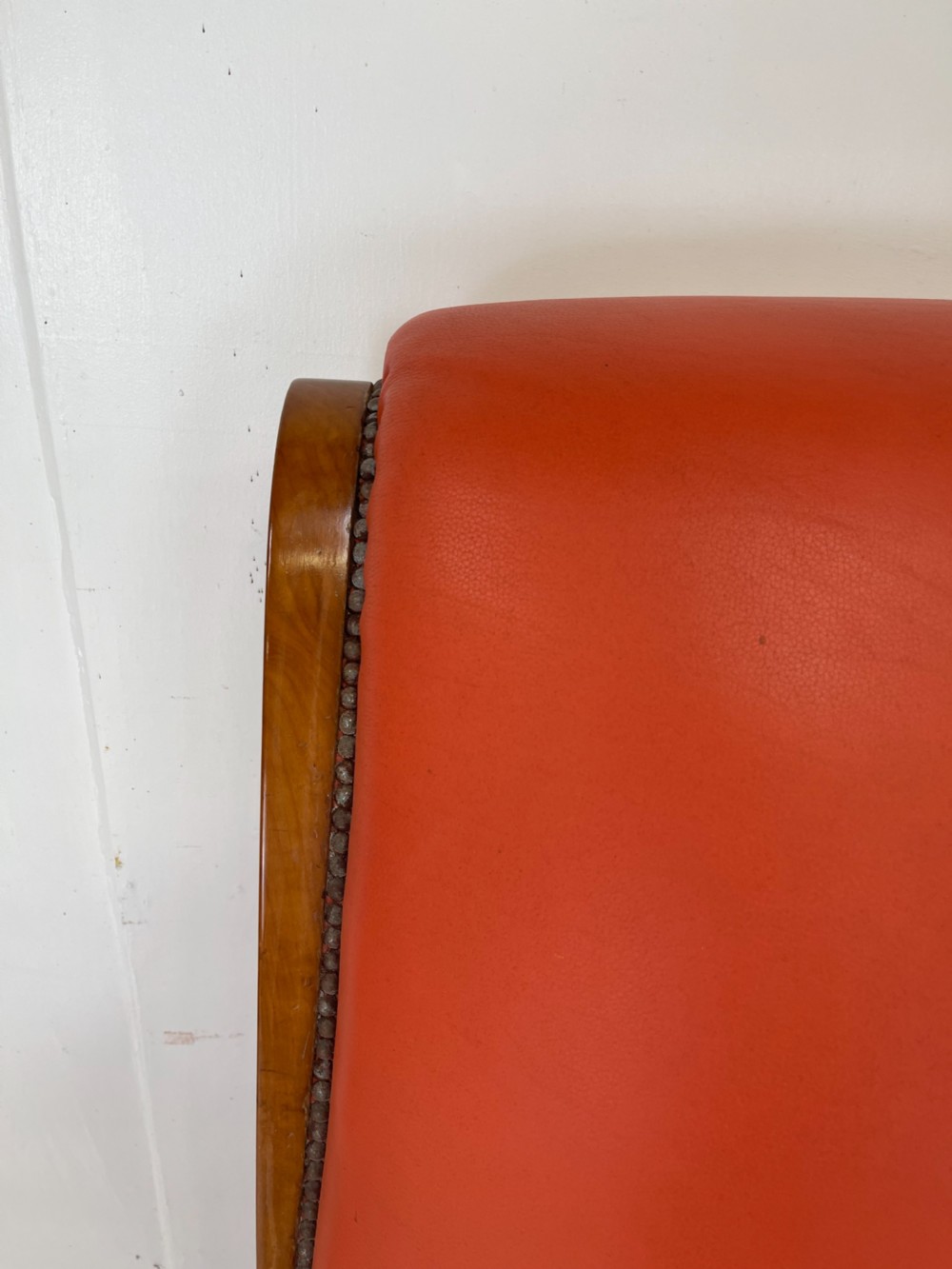 A pair of Art Deco high-backed armchairs upholstered in terracotta orange leather with dark wooden frames and bases. View IV