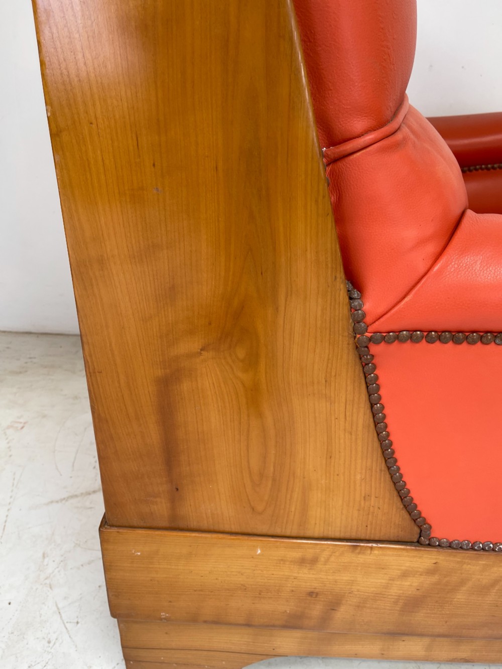 A pair of Art Deco high-backed armchairs upholstered in terracotta orange leather with dark wooden frames and bases. View VI