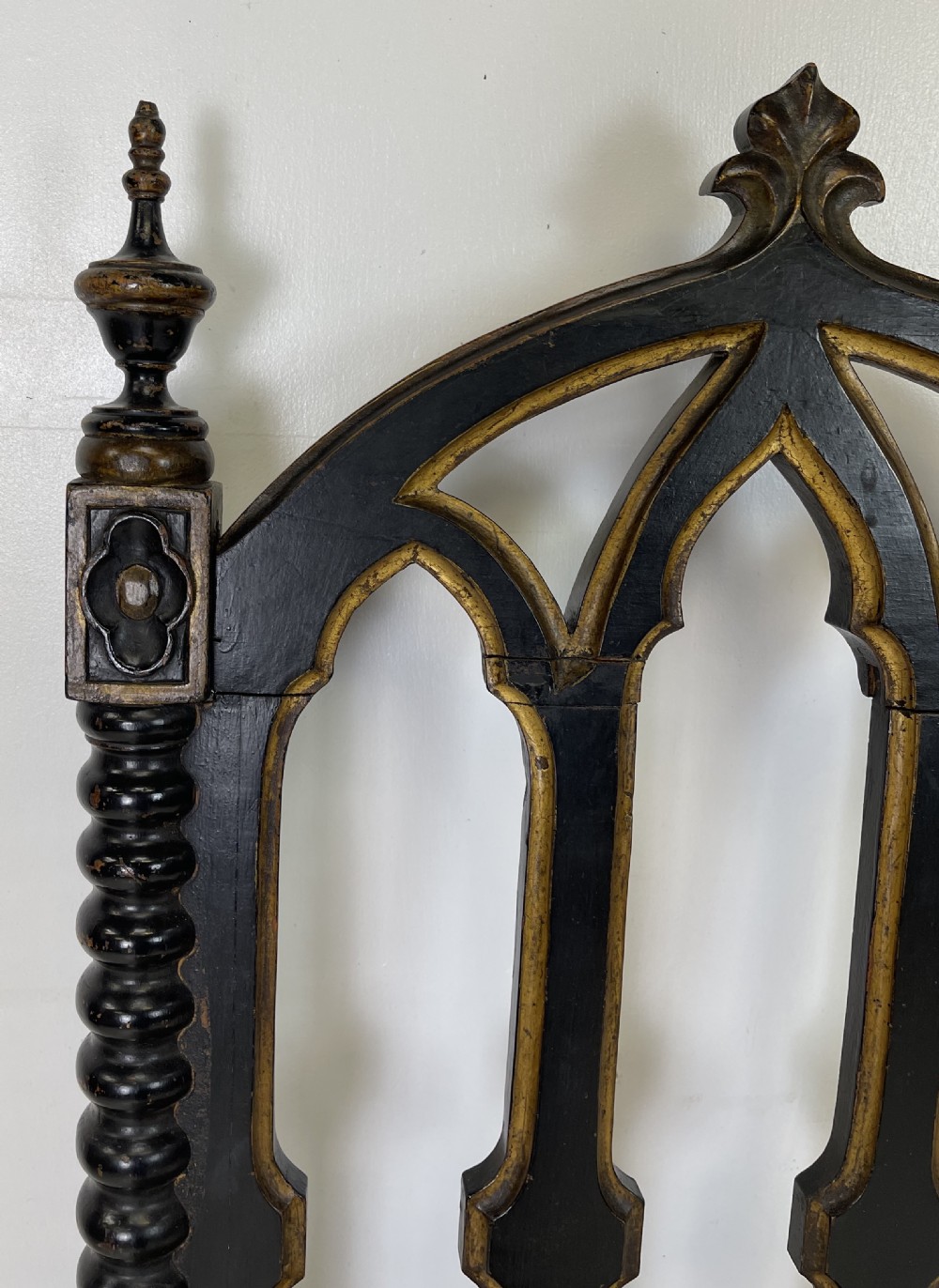A Victorian Gothic Revival side chair featuring an ebonised frame with lancet arch tracery, bobbin turned legs, and patterned cream upholstery with brass stud details. View IV