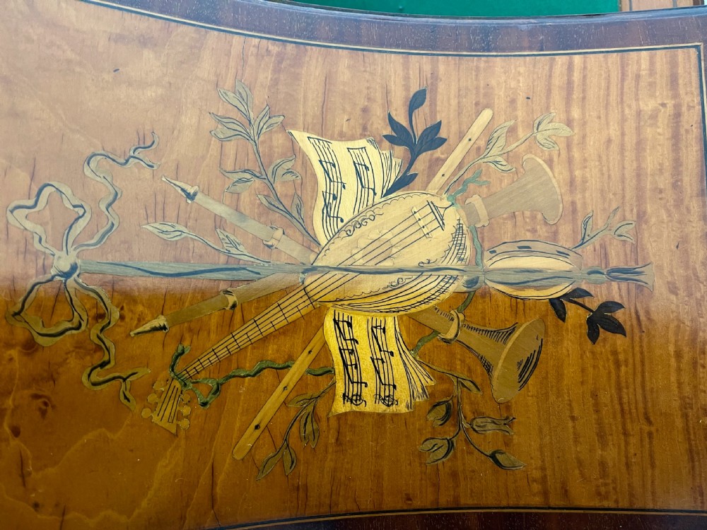 An Edwardian satinwood Carlton House desk with floral marquetry inlay, a green leather writing surface, multiple drawers, and a brass gallery top. View XIV