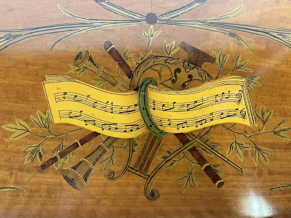 An Edwardian satinwood Carlton House desk with floral marquetry inlay, a green leather writing surface, multiple drawers, and a brass gallery top. View XV