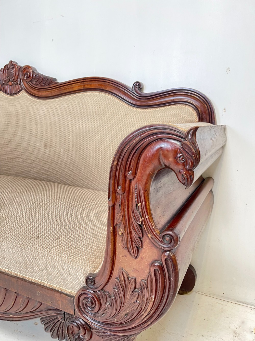 A large antique mahogany sofa featuring intricately hand-carved acanthus scrollwork along the apron and arms, upholstered in a light cream textured fabric. View II