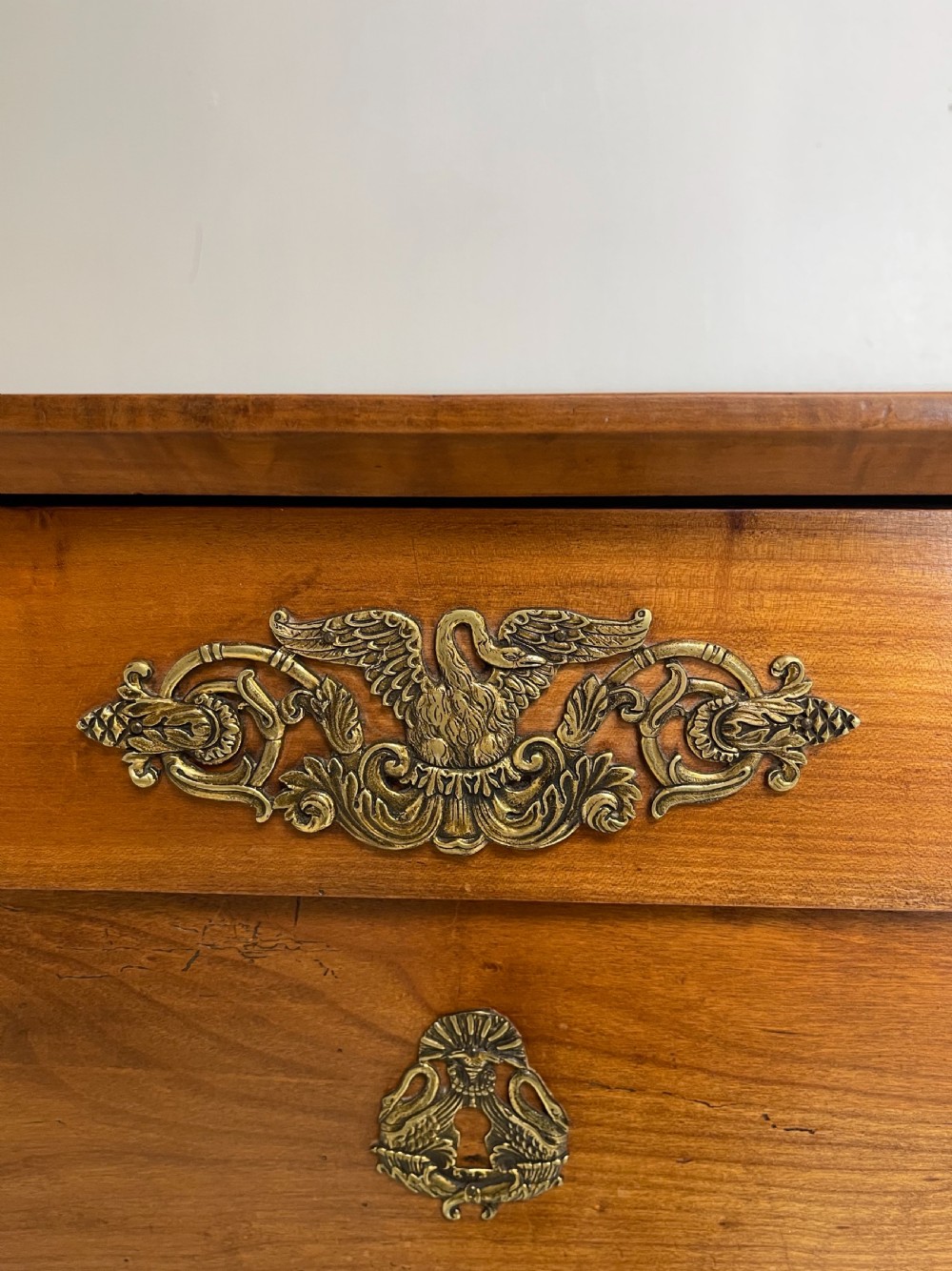 A tall French cherrywood semainier featuring seven drawers with brass drop handles and decorative keyhole escutcheons. View VI