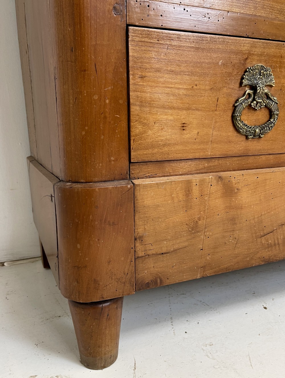 A tall French cherrywood semainier featuring seven drawers with brass drop handles and decorative keyhole escutcheons. View XI