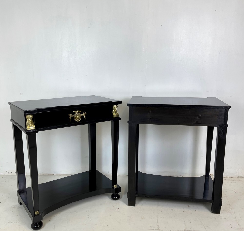 A pair of ebonised black side tables featuring single drawers, lower shelves, and gilt brass mounts on square legs. View IX