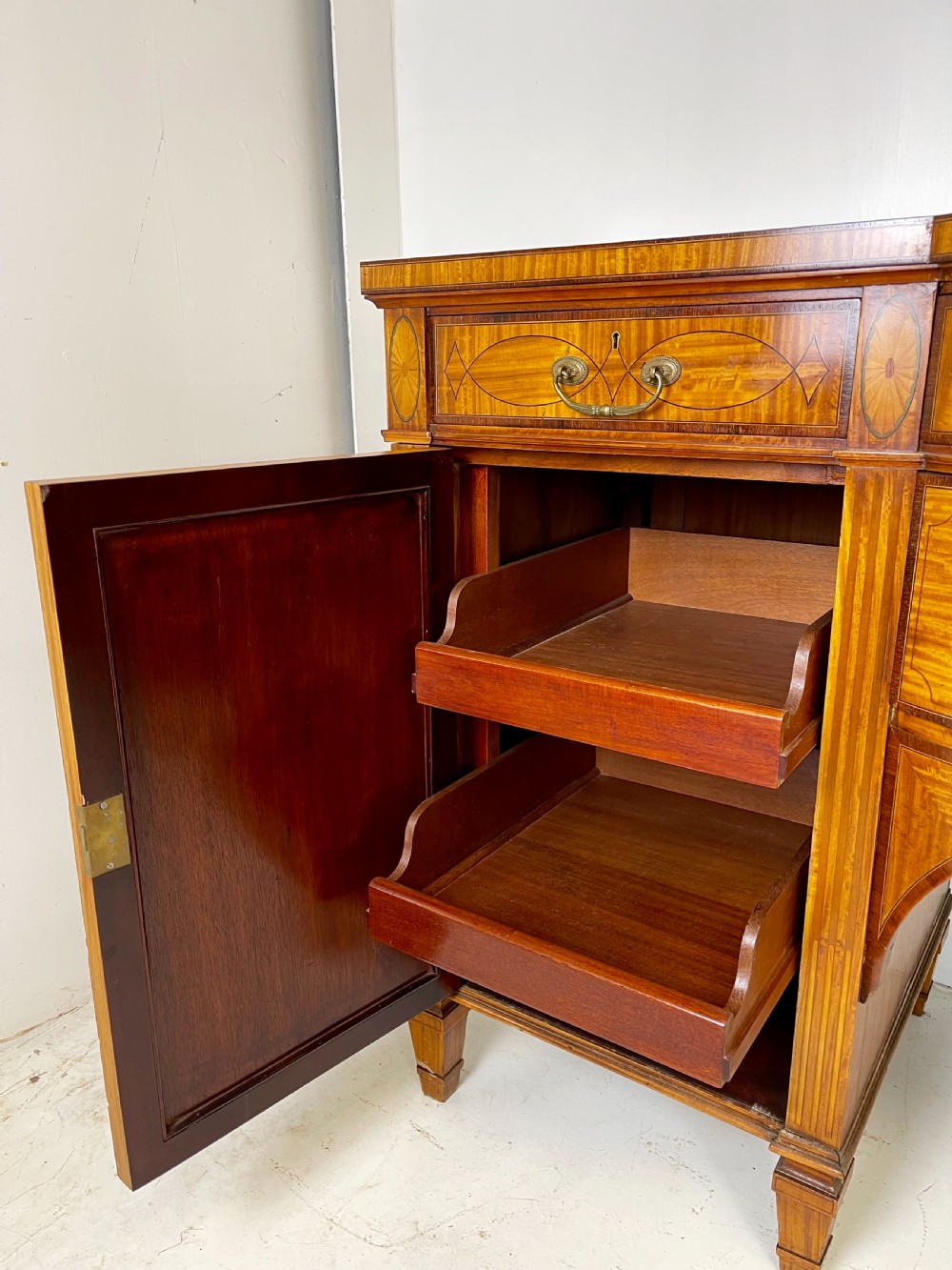 An Edwardian satinwood sideboard featuring oval marquetry inlays, drawers, two side cupboard doors, and tapered legs. View XIII
