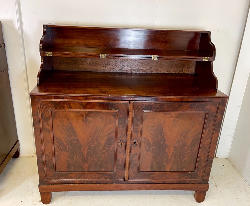 A pair of mahogany serving cupboards with flame veneer doors and folding upper gallery shelves. View II