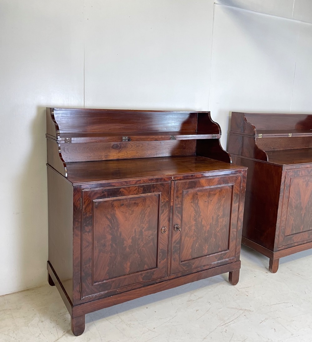 A pair of mahogany serving cupboards with flame veneer doors and folding upper gallery shelves. View III