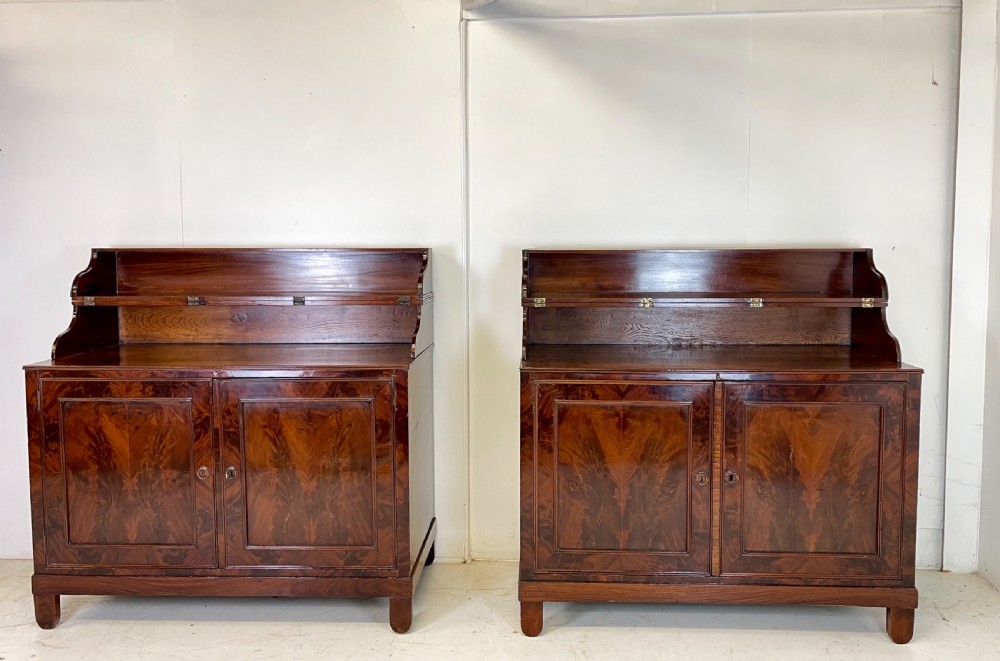 A pair of mahogany serving cupboards with flame veneer doors and folding upper gallery shelves. View VI
