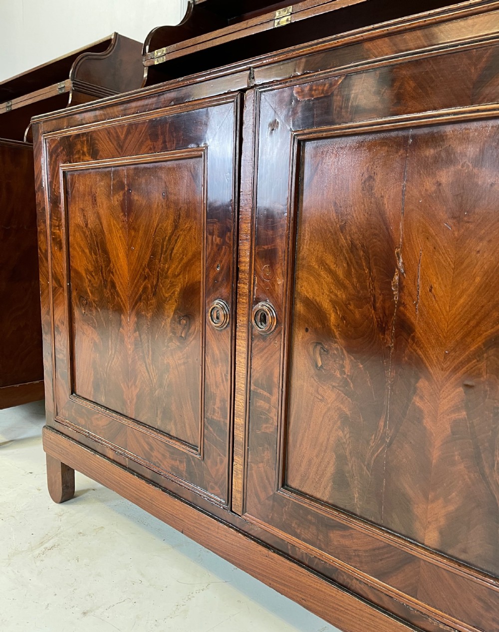 A pair of mahogany serving cupboards with flame veneer doors and folding upper gallery shelves. View VIII
