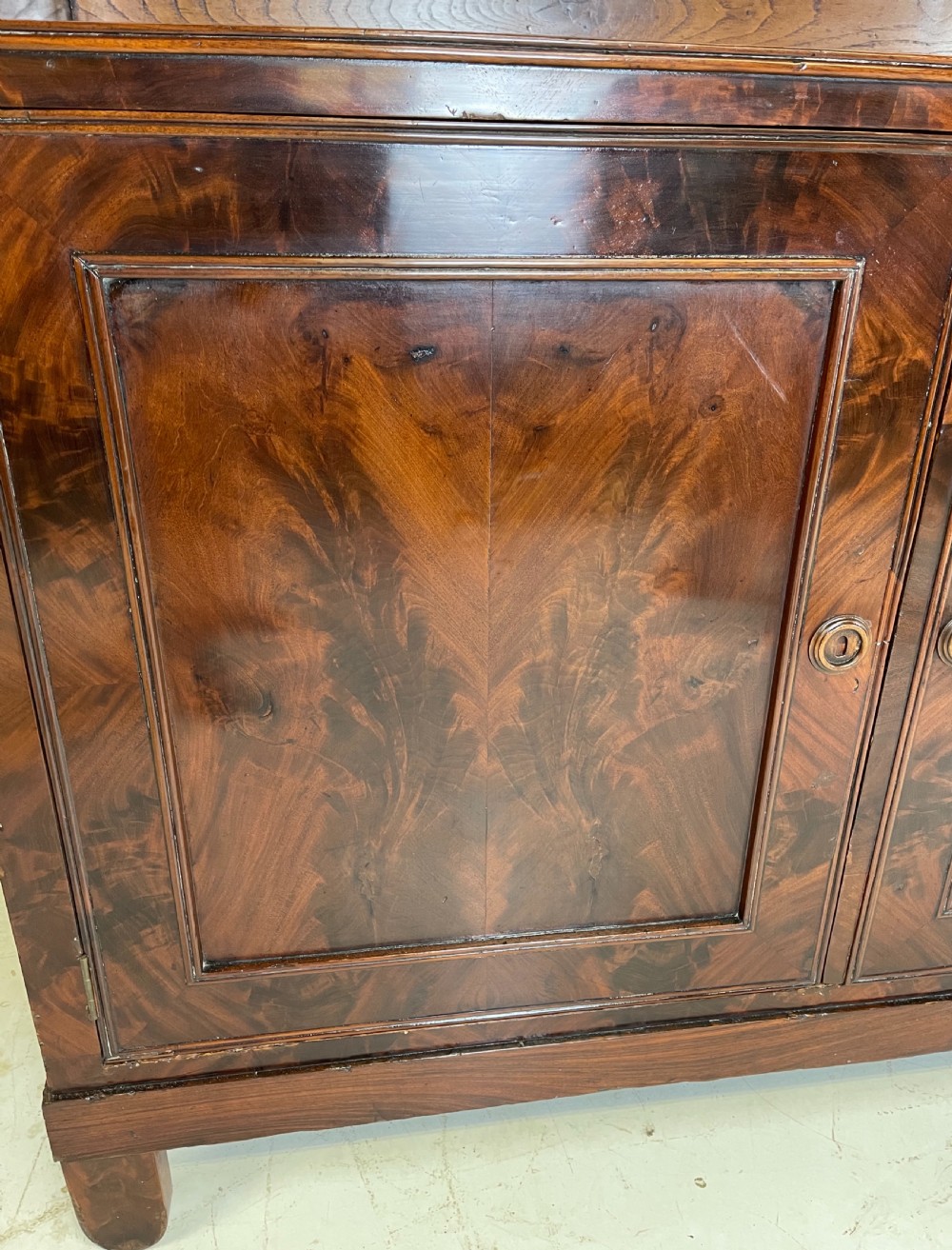 A pair of mahogany serving cupboards with flame veneer doors and folding upper gallery shelves. View IX