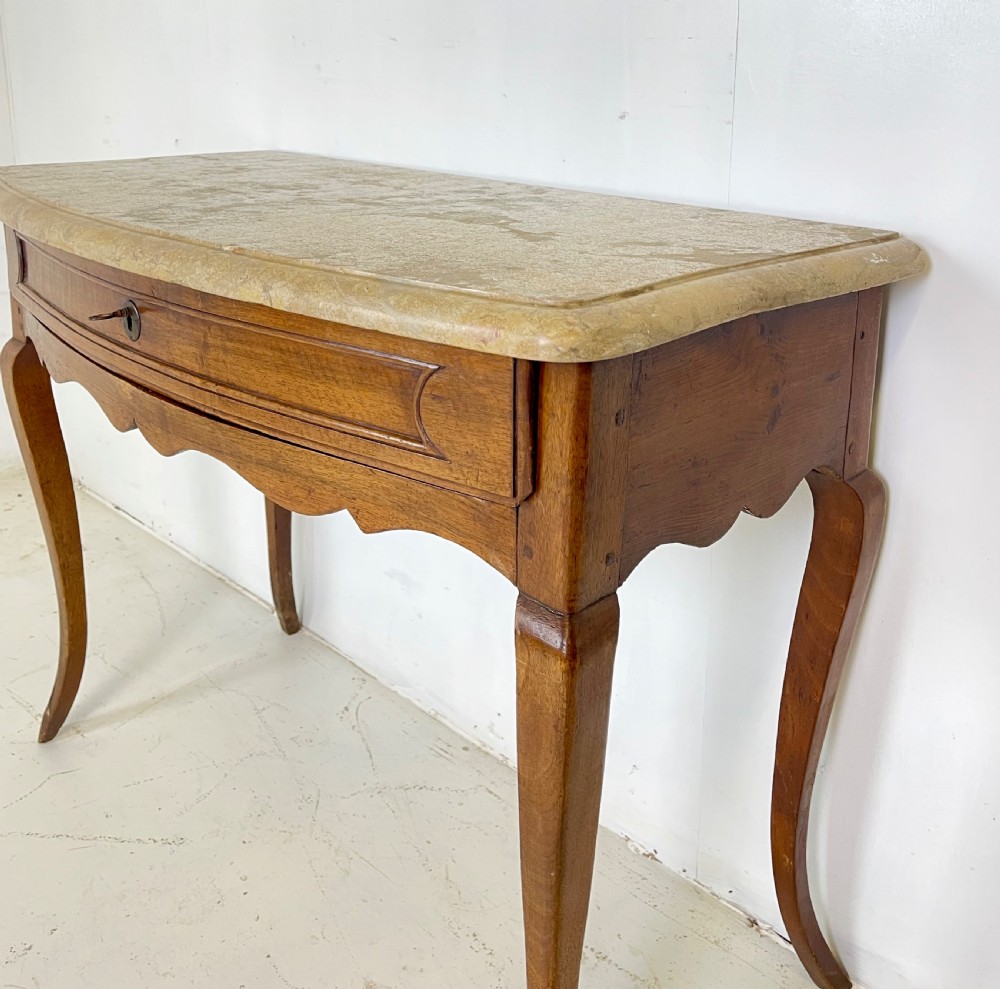 An antique French Provincial side table featuring a grey marble top, a single drawer with a carved apron, and slender cabriole legs. View III