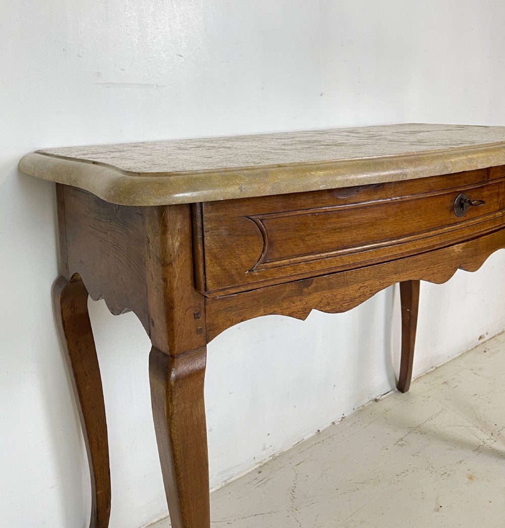 An antique French Provincial side table featuring a grey marble top, a single drawer with a carved apron, and slender cabriole legs. View VI